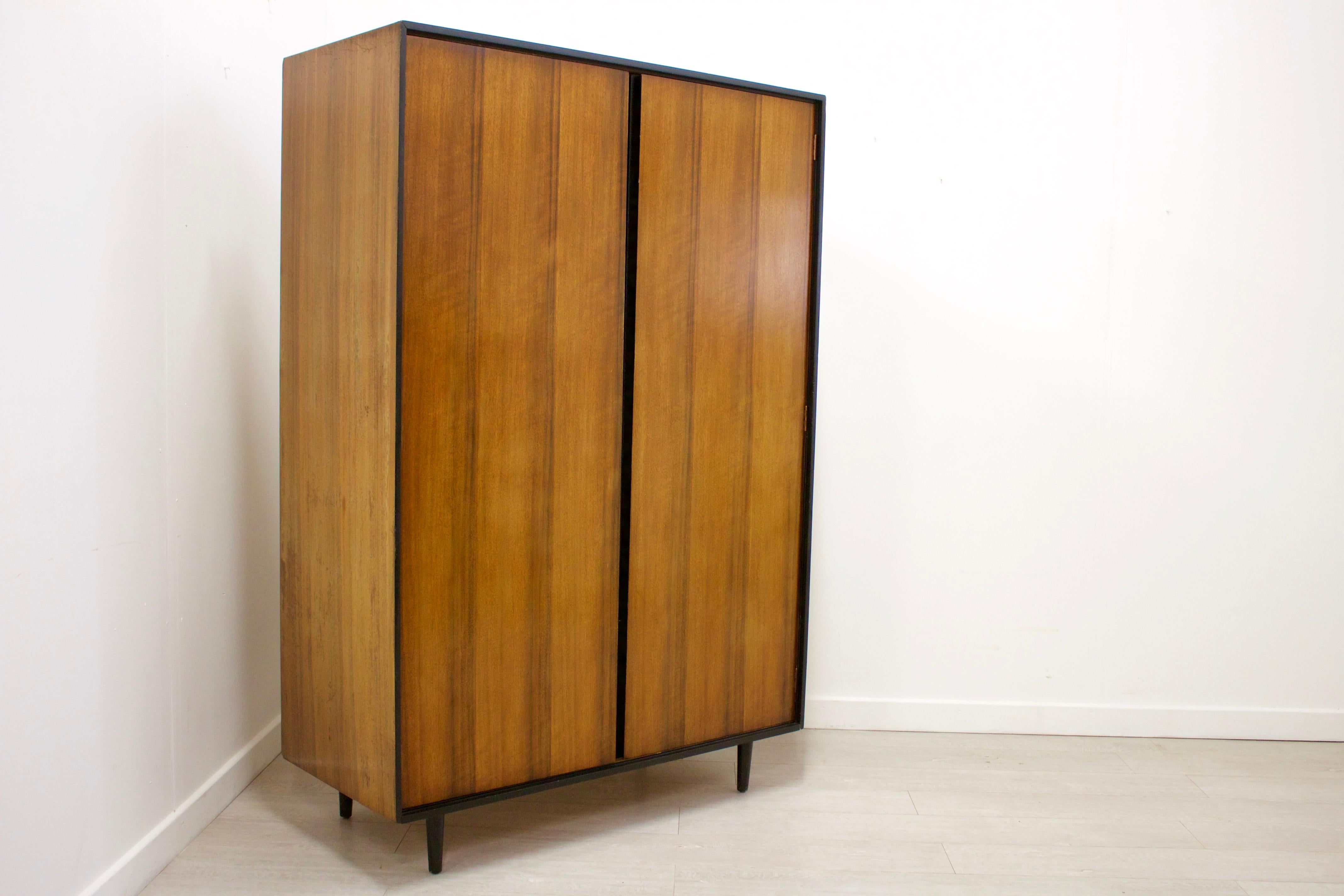 This is a very stylish walnut wardrobe by John & Sylvia Reid for Stag.
Features a mirror on the inside of the right door, a hanging rail to the left and shelves to the right for ample storage.