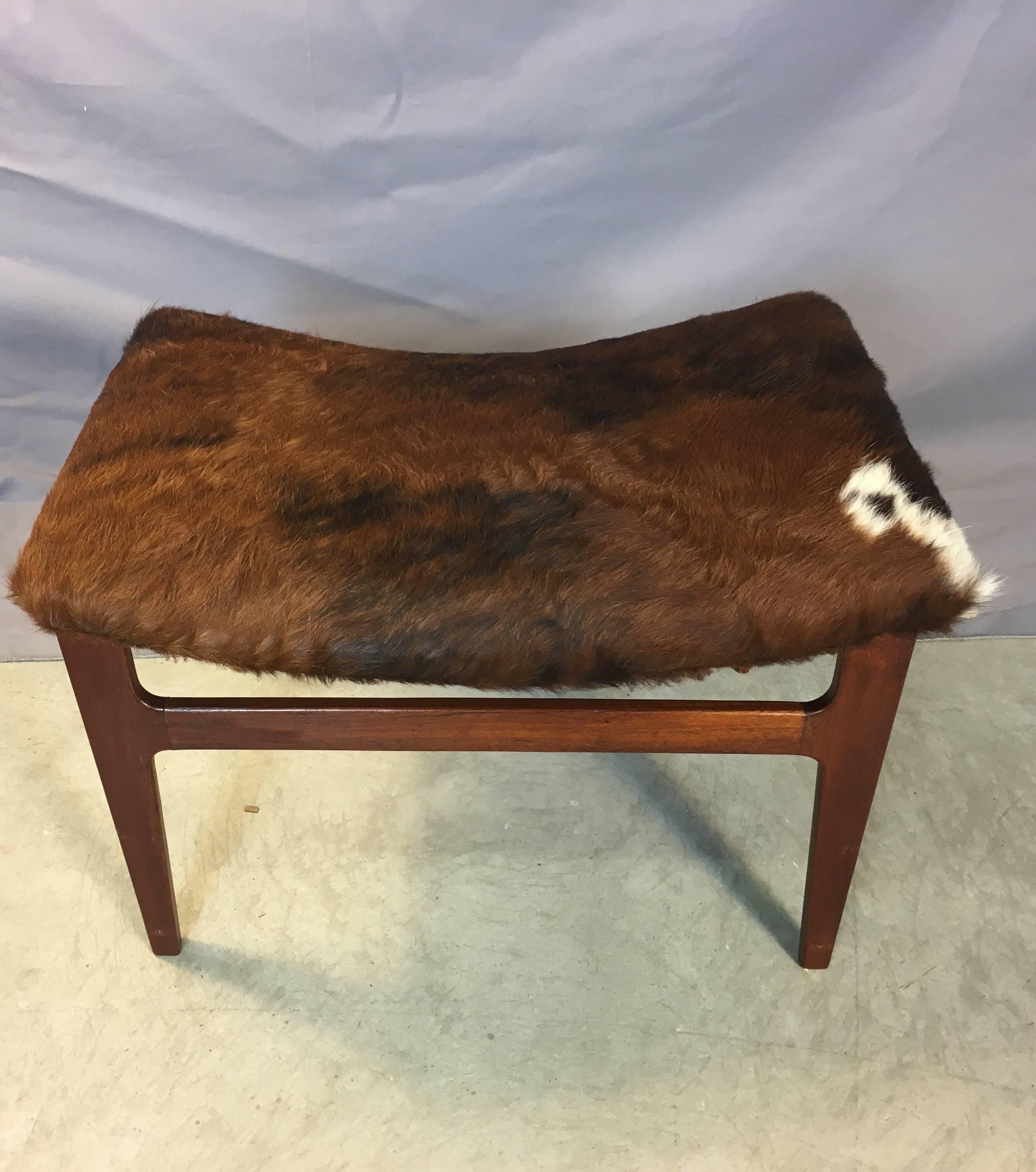 Vintage 1960s walnut wood rectangular footstool with a new brown cowhide seat. No mark.