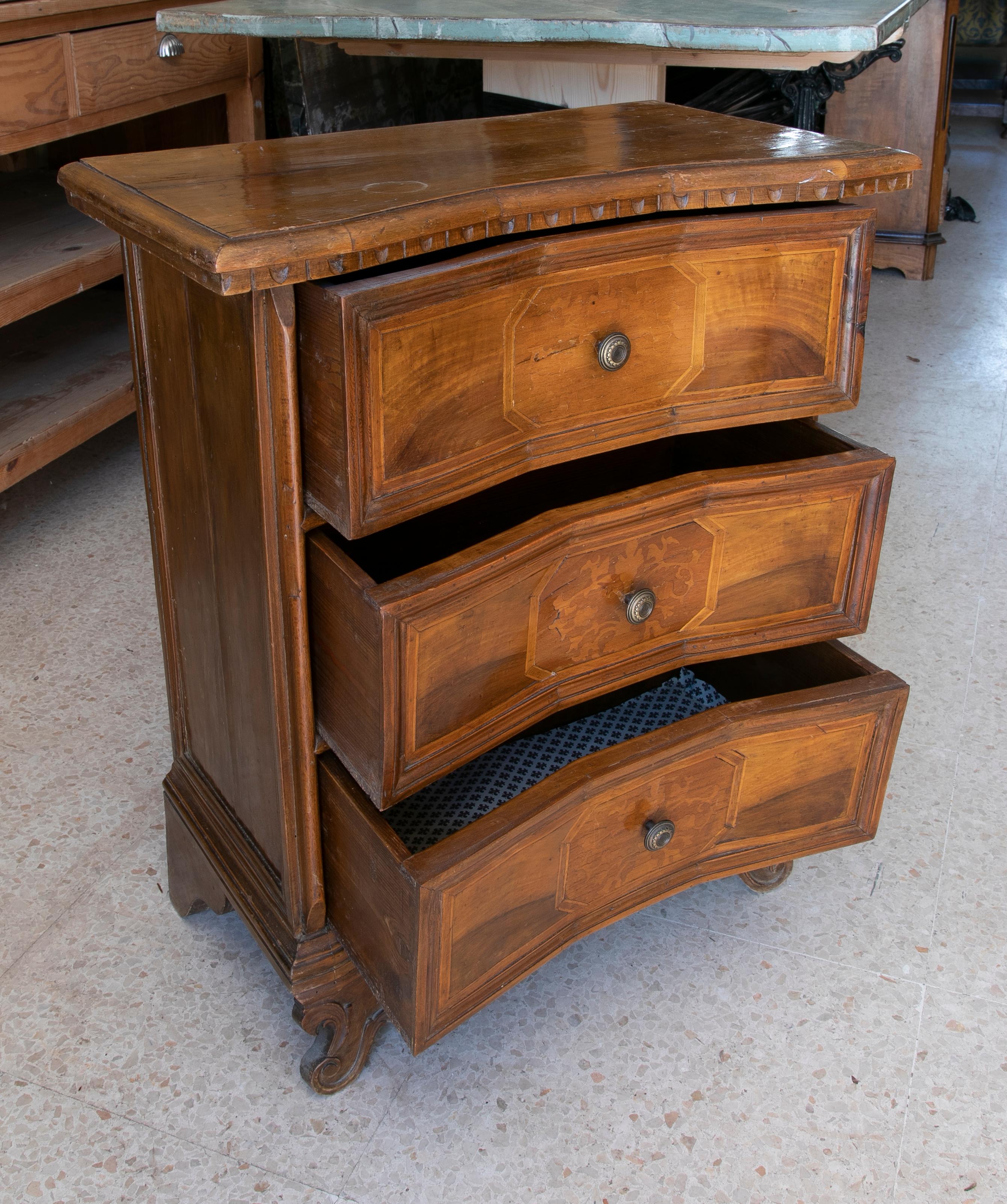 Hand-carved and inlaid walnut chest of drawers with three drawers and bronze handles.