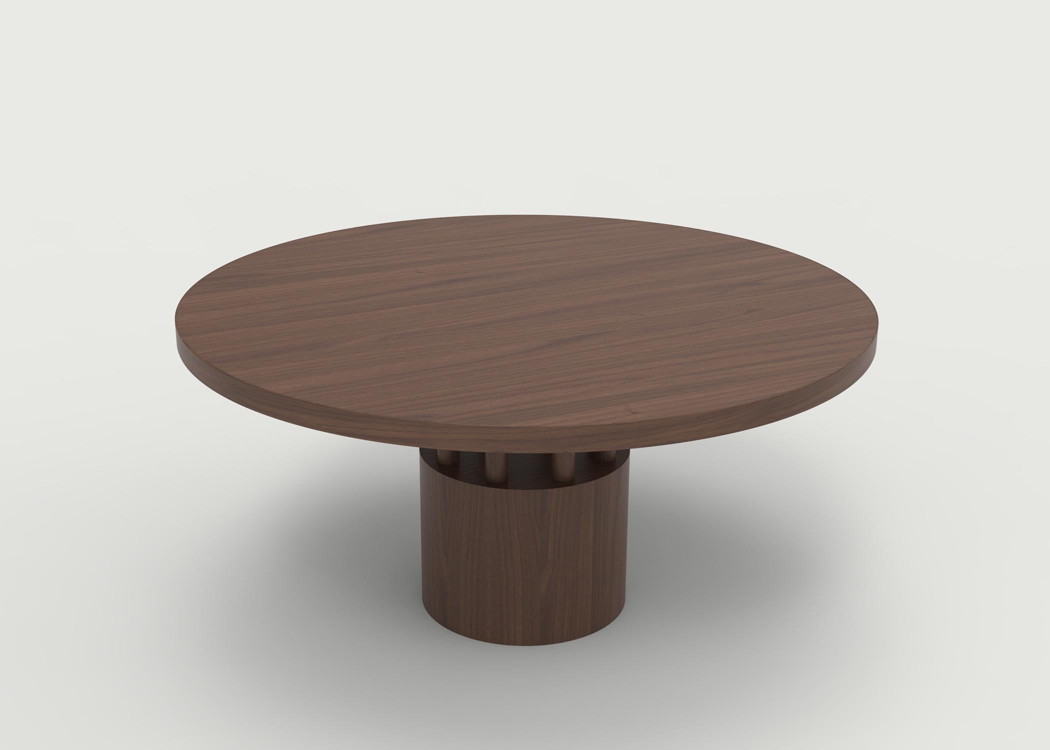 La table de salle à manger Fulton est l'aînée de notre table basse Benson - plateau rond avec des veines de bois soigneusement sélectionnées pour mettre en valeur la beauté de l'essence. La base et les poteaux situés en dessous donnent un aspect