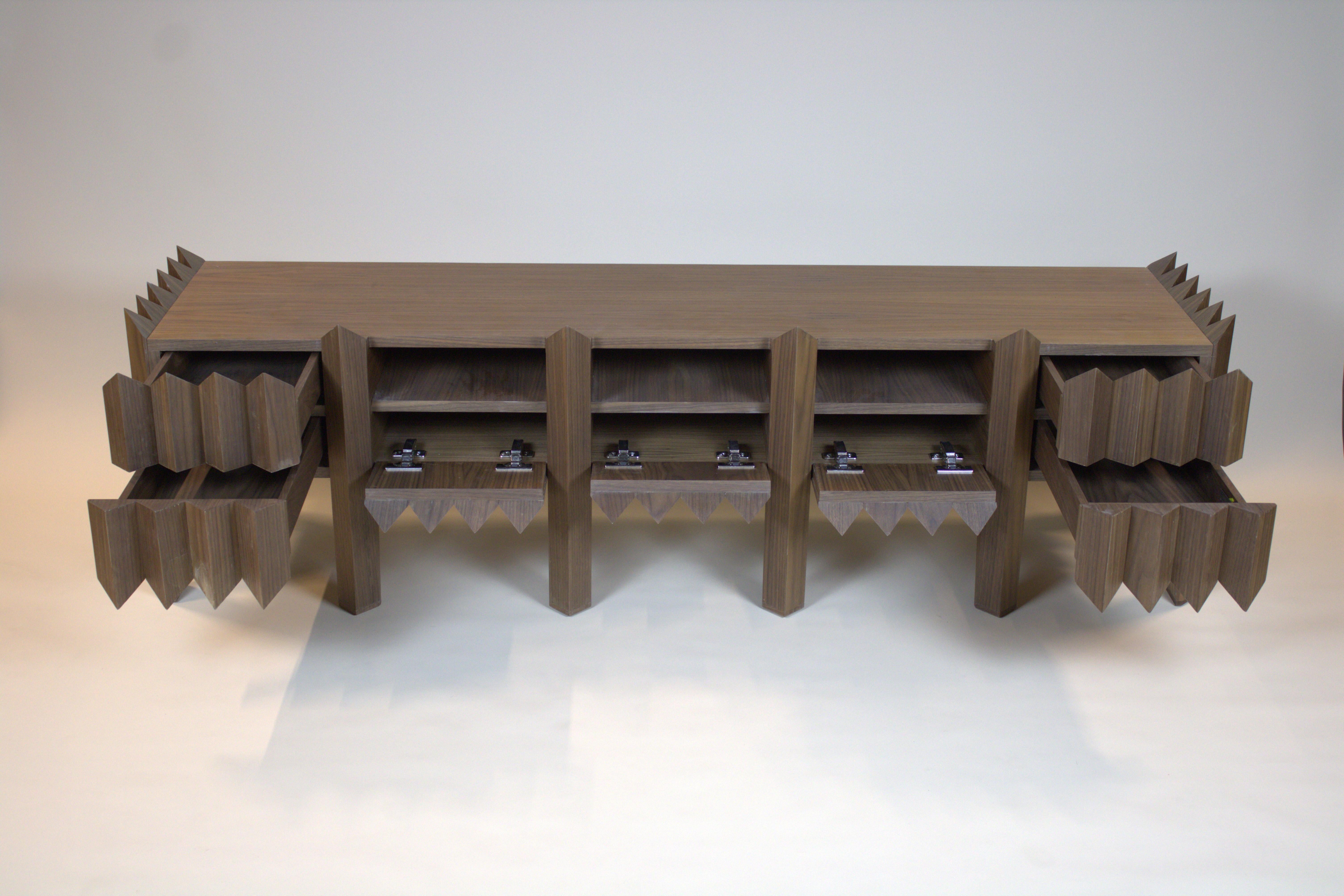 Le Mobil TV in metamorfosi est un meuble TV composé de triangles. Ce mobilier est en accord avec le Tavolo in metamorfosi. Pour compléter l'ensemble, il vous faut une table basse et une table d'appoint du même style. Cette commode a quatre tiroirs