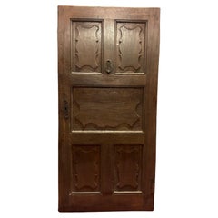 Antique Walnut wood entrance door with one-leaf door and carved wavy panels, Italy
