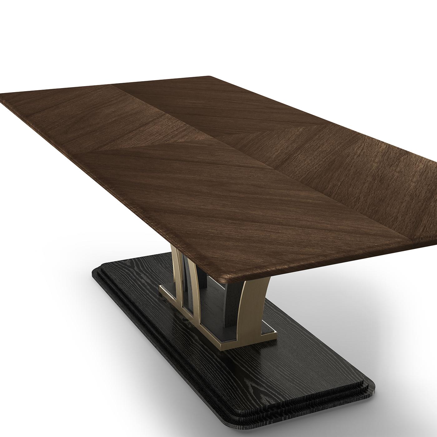 The striking base of this dining table creates a geometric symmetry of curved elements that perfectly showcases a Canaletto walnut rectangular top enriched with halo-shaped inlay work. The structure of the table is in plywood and flamed ash-veneered