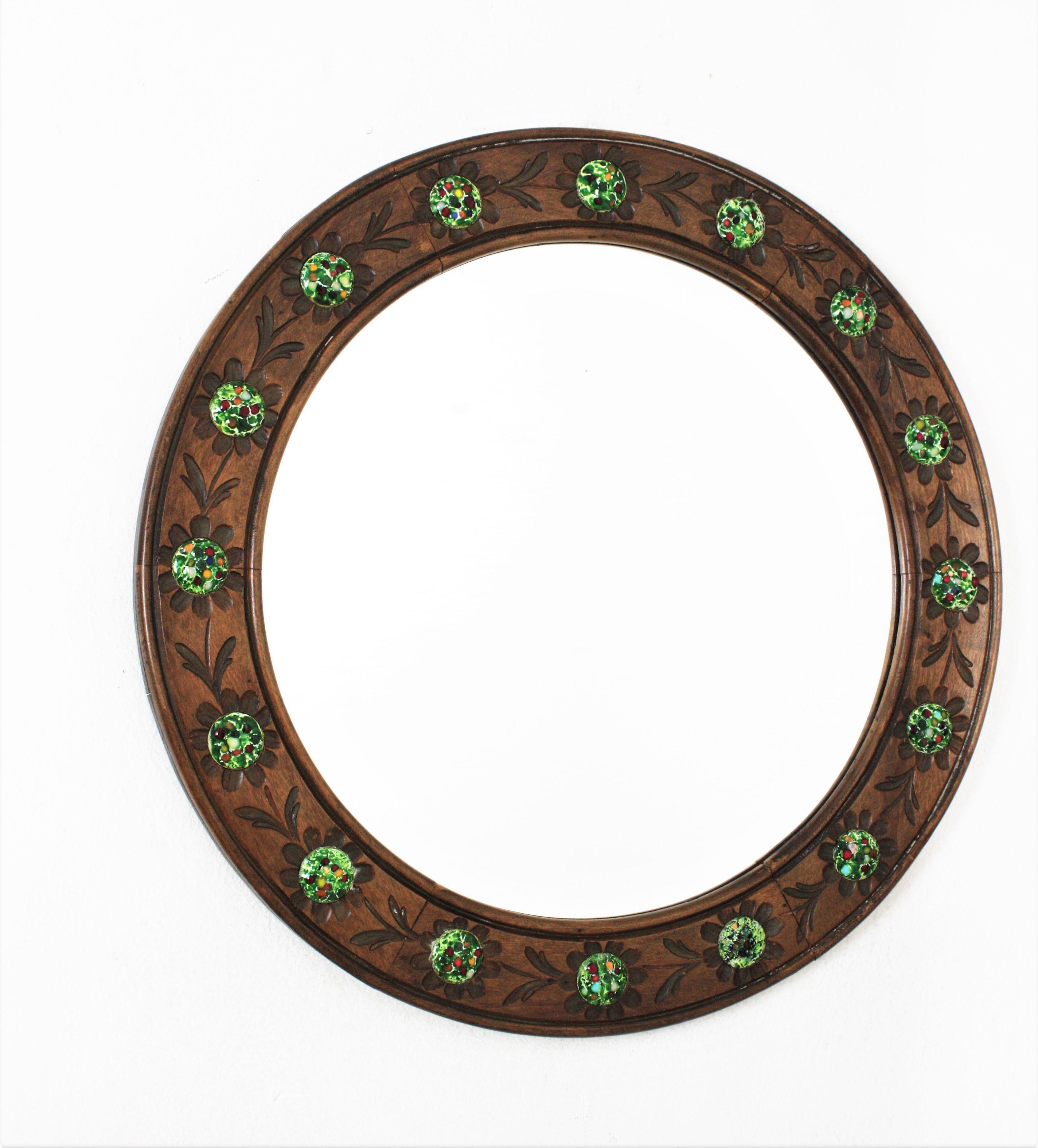 Round Wall Mirror, Walnut, Enamel, Spain, 1960s.
This wall mirror features a wooden frame surrounding a round glass. The frame has carved flowers and round multicolor enamel decorative details on the flower's central part.
This wall mirror has a