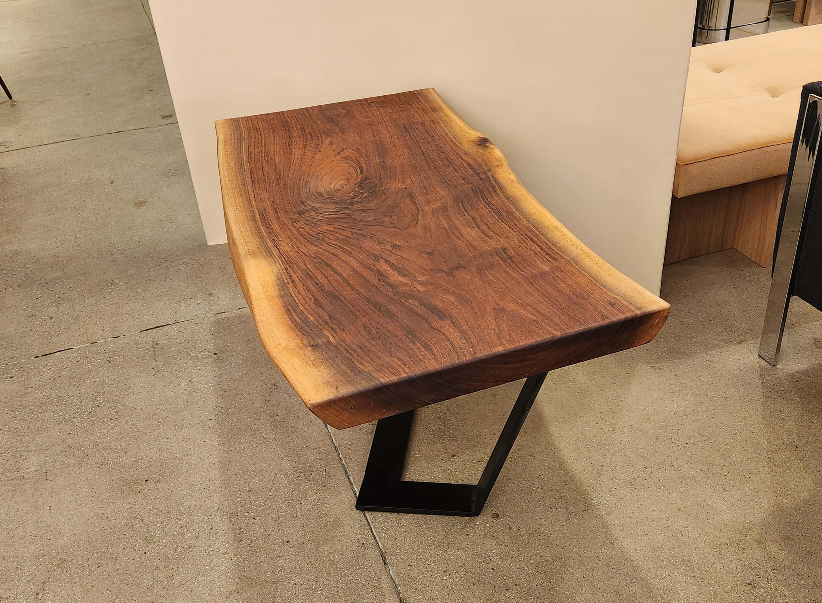 This tall walnut slab coffee table is a unique piece that is both functional and artisanal.
 
 It was designed by Creation Therrien. It is made from Pennsylvania black walnut wood polished to a smooth finish and coated with several layers of