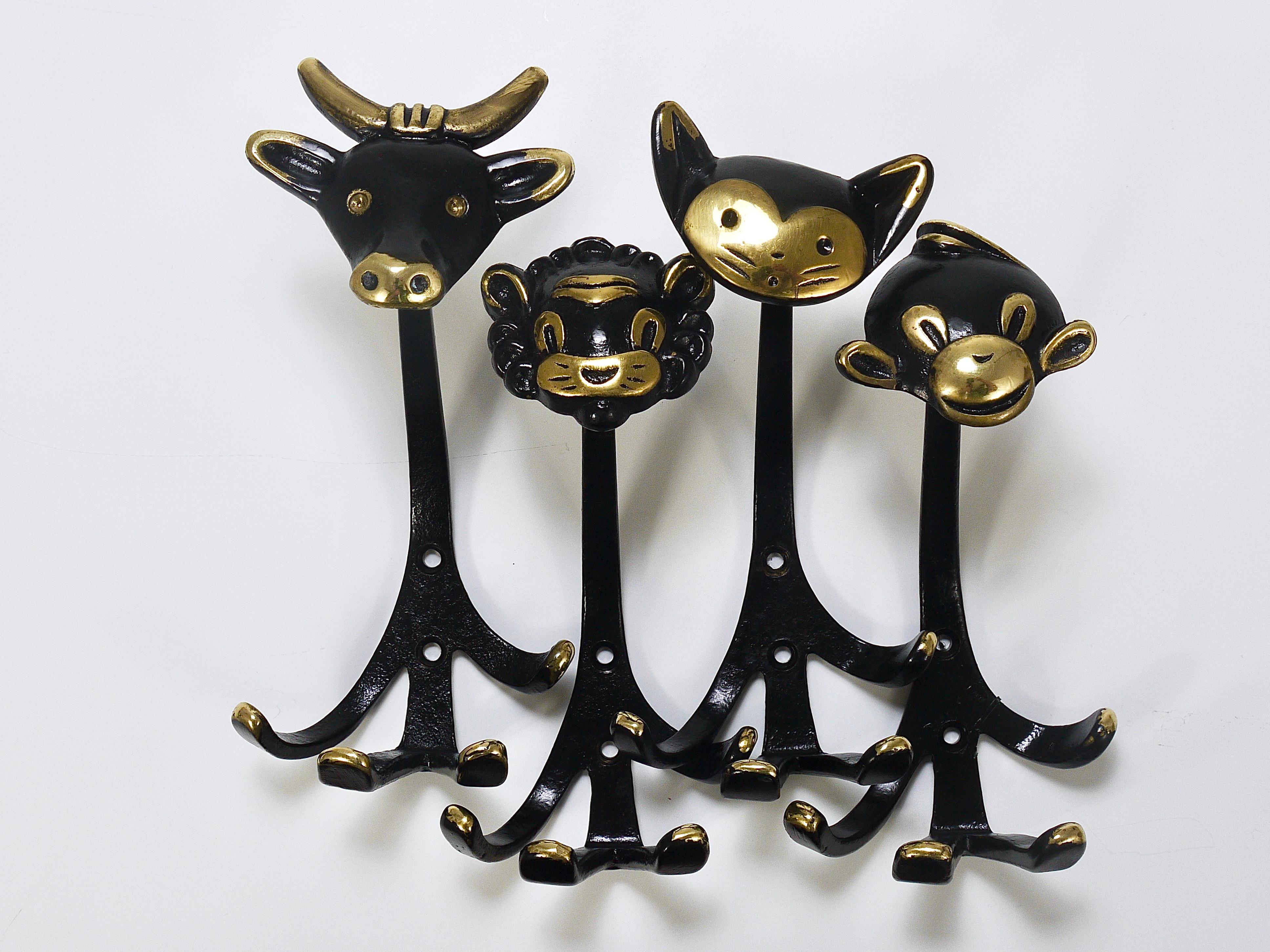 A set of 4 different lovely Austrian modernist animal zoo coat wall hooks, displaying a cow, lion, cat and monkey . A humorous design by Walter Bosse, executed by Herta Baller, Vienna / Austria in the 1950s. Made of black finished and partly