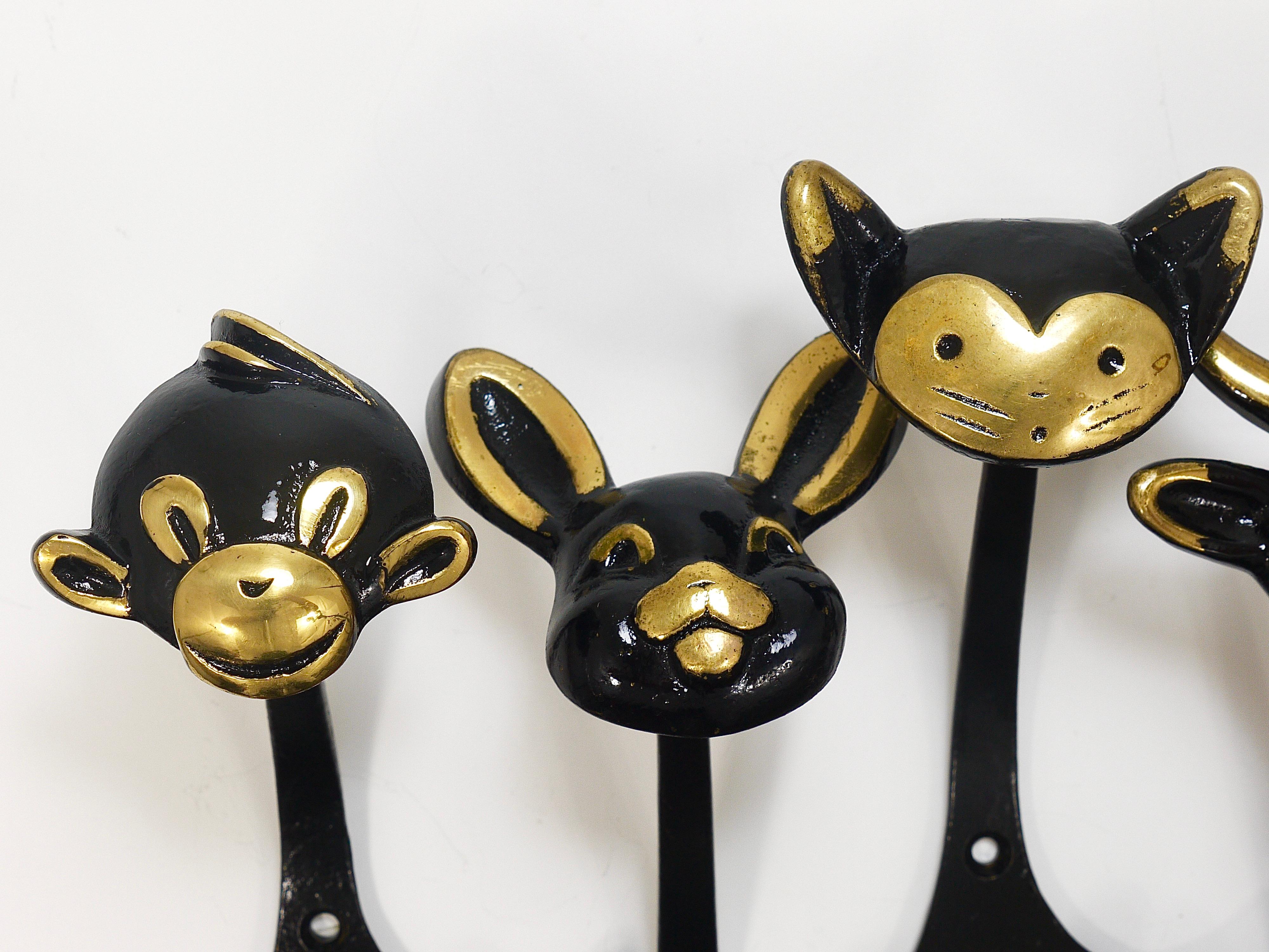 A set of 5 different lovely Austrian modernist animal zoo coat wall hooks, displaying a monkey, rabbit, cat, cow and a lion, . A humorous design by Walter Bosse, executed by Herta Baller, Vienna / Austria in the 1950s. Made of black finished and