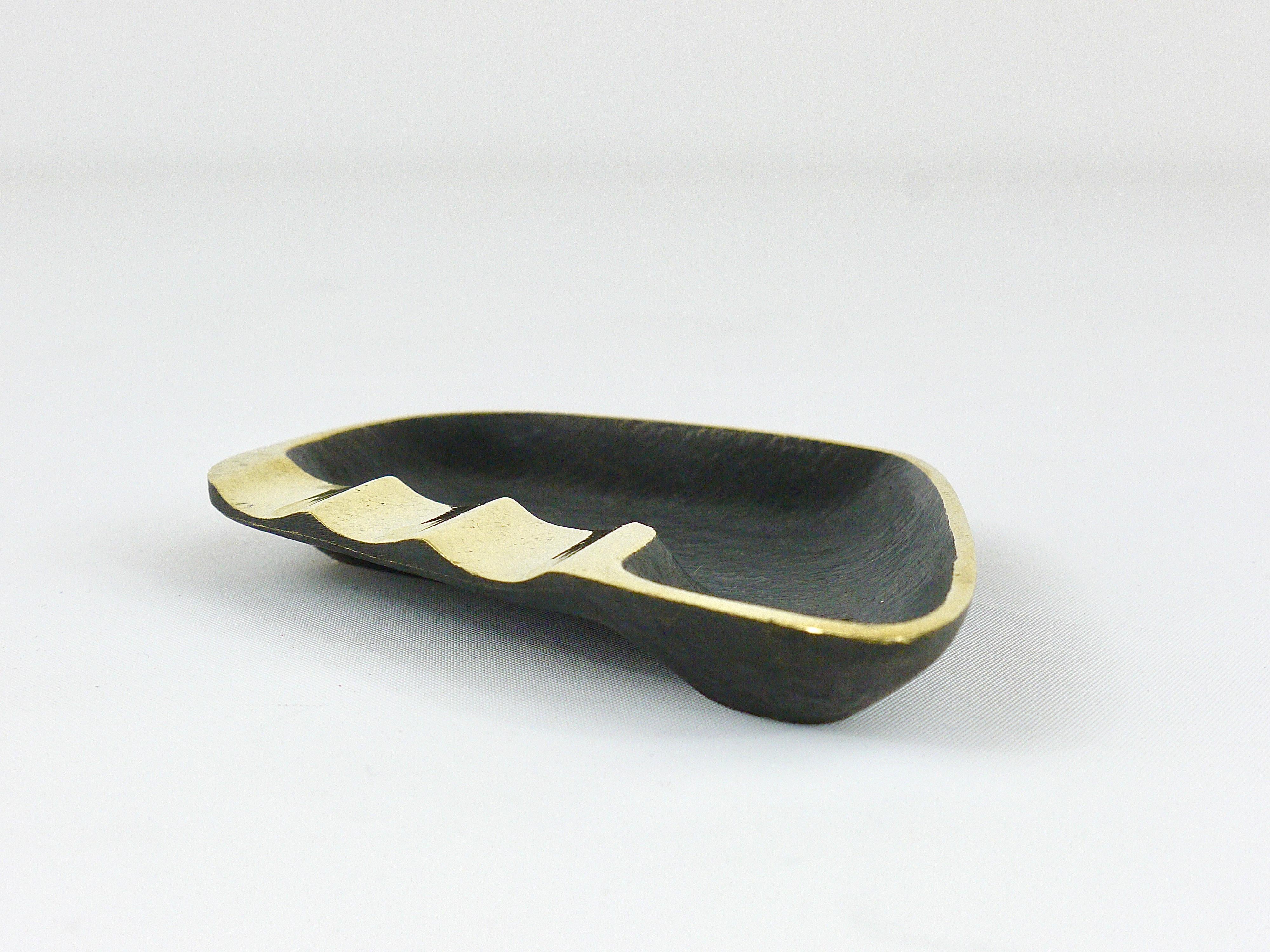 A stylish modernist ashtray with amazing asymmetrical shape. Designed by Walter Bosse, executed by Hertha Baller Austria in the 1950s. Made of brass, in good condition with nice patina.