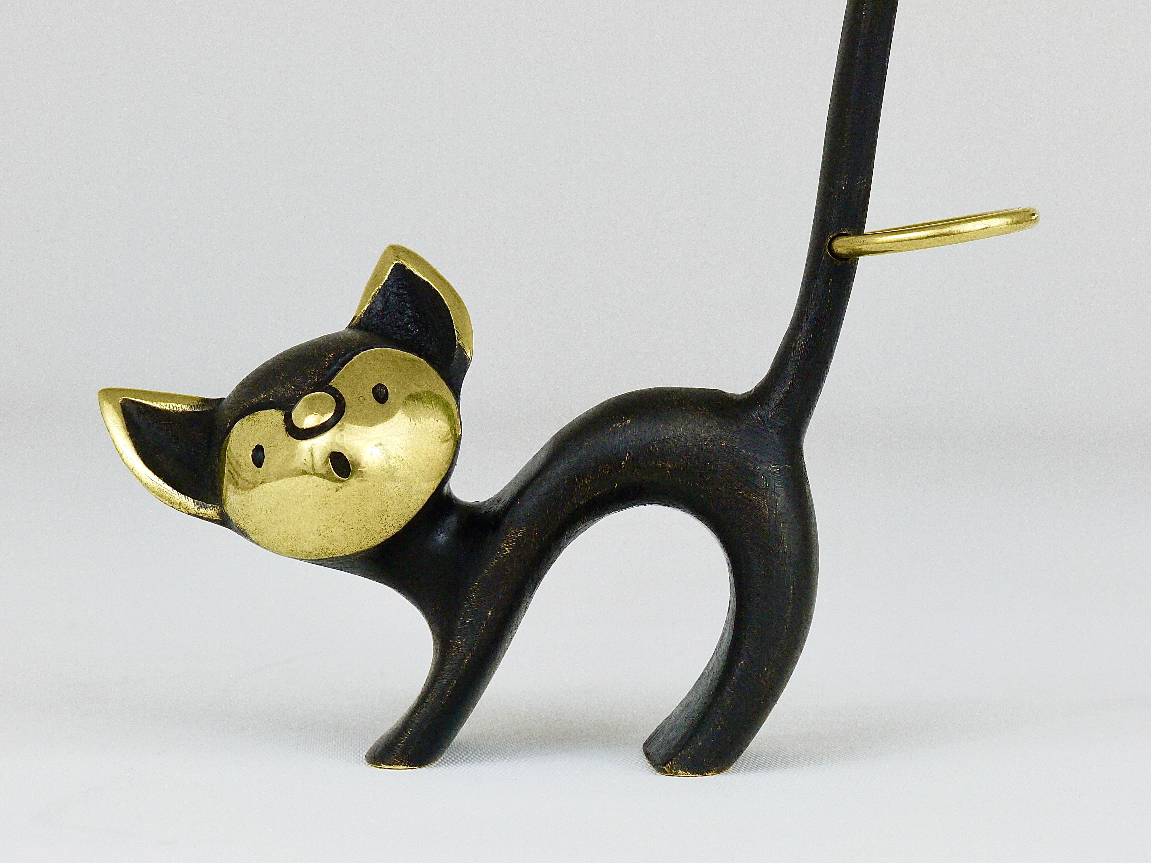 Charmante figurine autrichienne de chat en laiton, fabriquée à l'origine pour être utilisée comme porte-bretzel, une pièce décorative, qui convient très bien comme porte-bague. Un design très humoristique de Walter Bosse, exécuté par Hertha Baller,