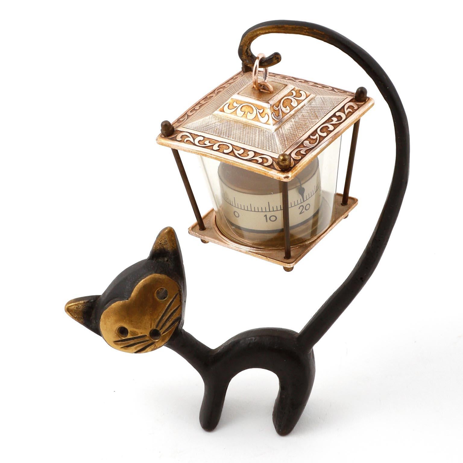 A cat which holds a thermometer by its tail by Walter Bosse and manufactured by Hertha Baller, Austria, Vienna, in midcentury in 1950s.
The cat is made of blackened and polished brass. The thermometer shows the temperature in degree Celcius and not