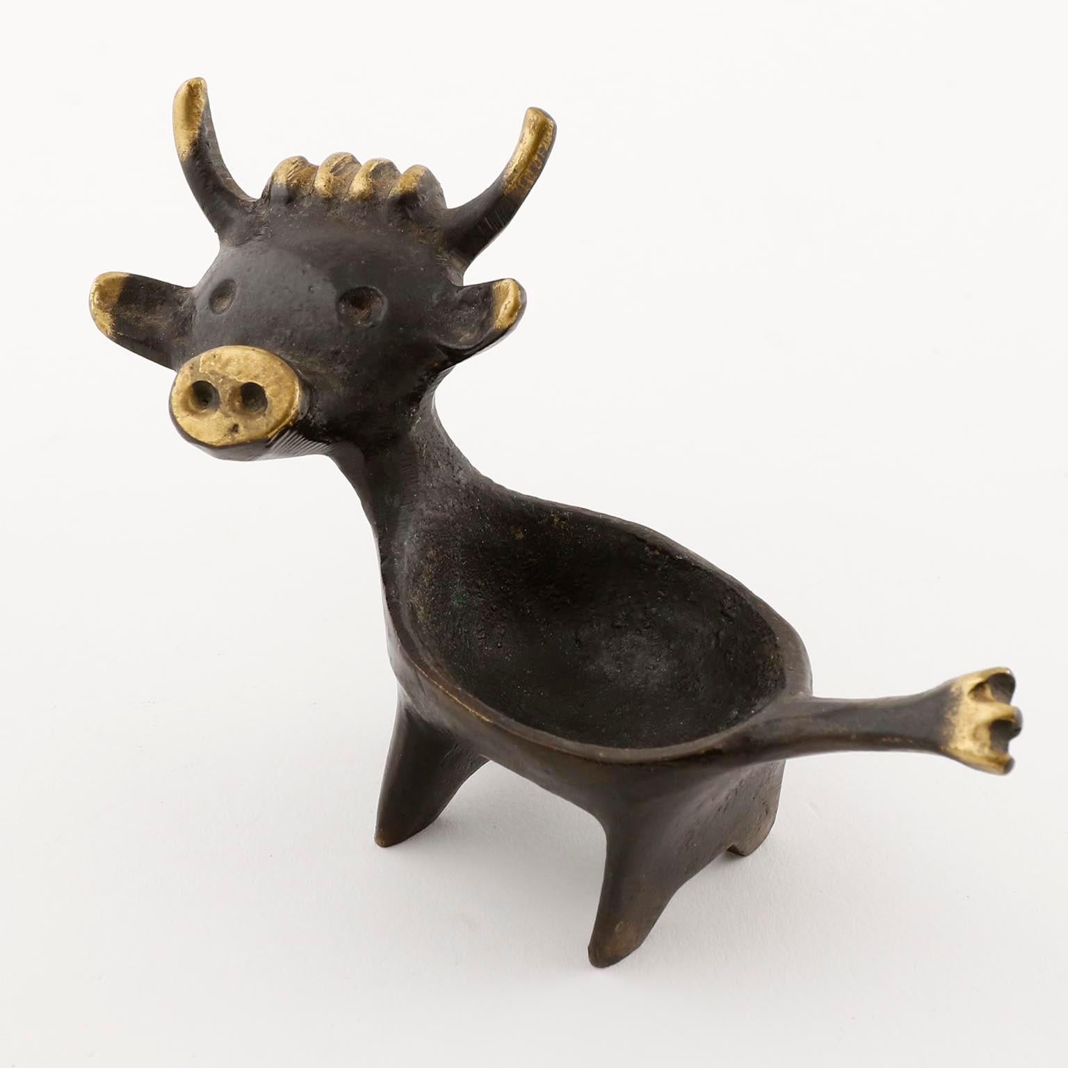 A candleholder in the form of a cow by Walter Bosse and manufactured by Hertha Baller, Austria, Vienna, in midcentury, circa 1960 (late 1950s or early 1960s).
The candleholder is made of blackened and polished brass. It can be used for small ball