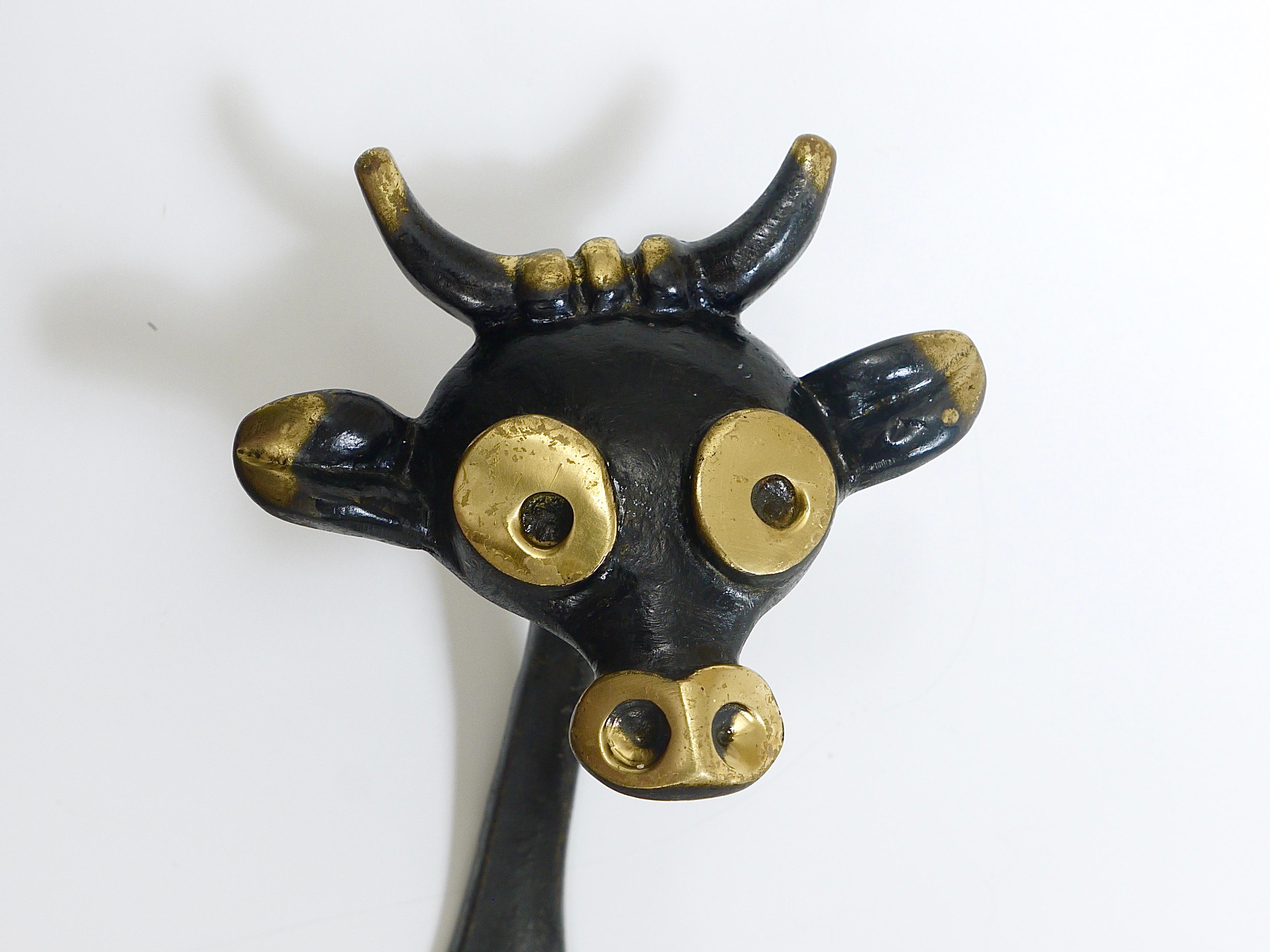 A lovely Austrian modernist animal coat wall hook, displaying a cow. A humorous design by Walter Bosse, executed by Hertha Baller Austria in the 1950s. Made of black finished and partly polished brass. In good condition with nice patina. The hook