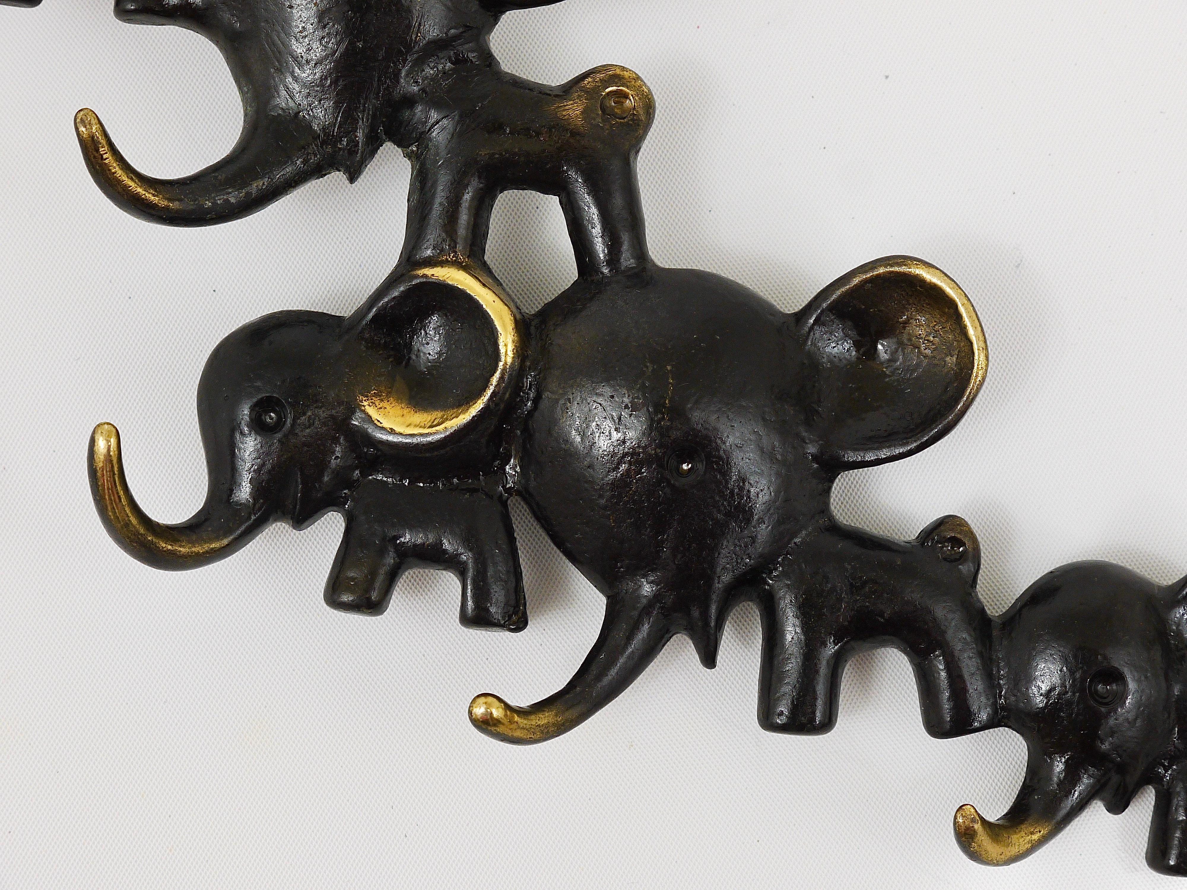 A charming and rare key holder, displaying an elephant family. A very humorous design by Walter Bosse, executed by Hertha Baller, Austria, in the 1950s. Also suitable as a towel holder or for dish towels in the kitchen. Made of brass, in very good