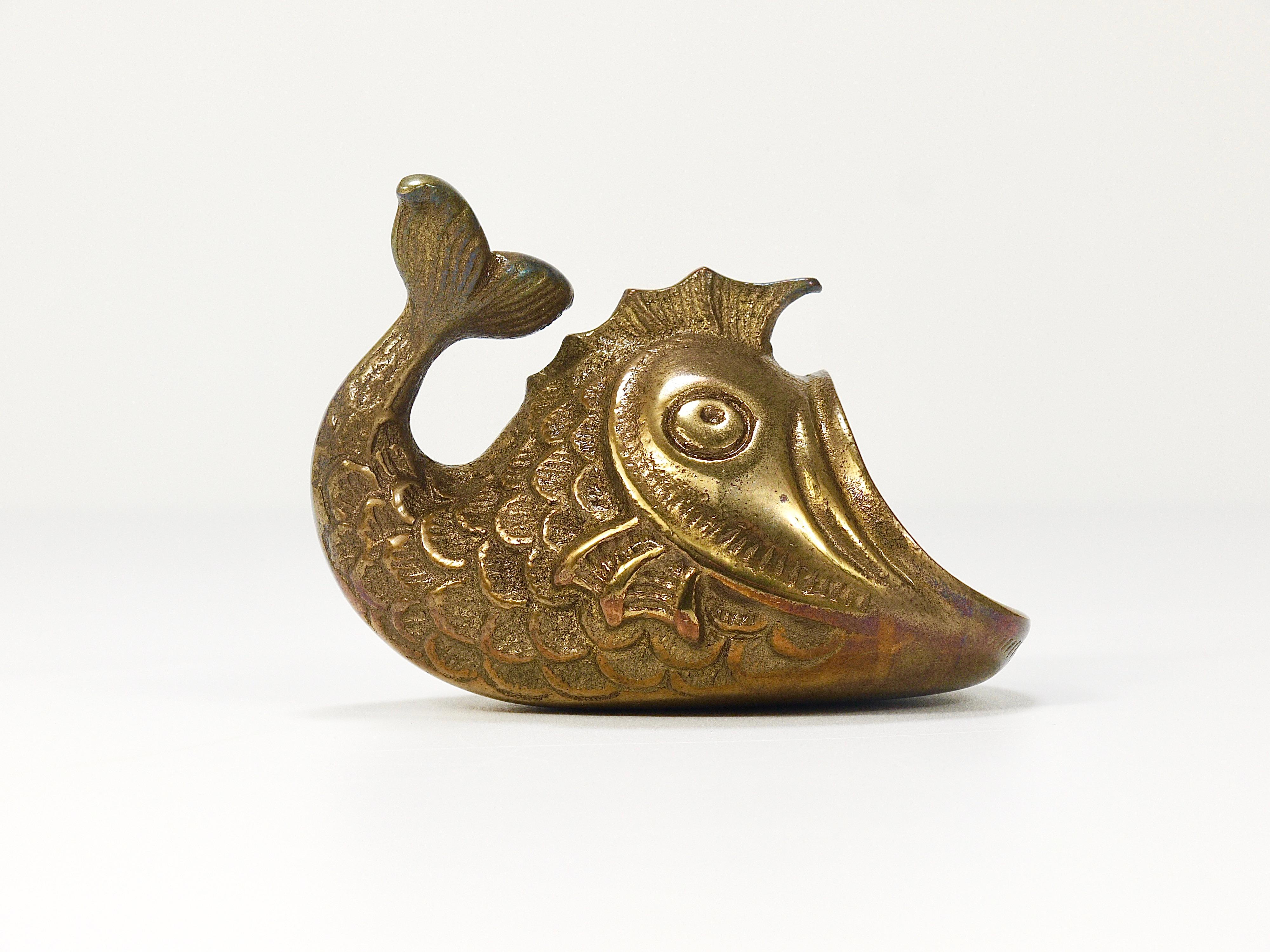 A charming Austrian midcentury brass ashtray from the 1950s, displaying a fish. A humorous design by Walter Bosse for Werkstätte Hagenauer Vienna. Made of solid brass. In good condition with marginal patina. A decorative attention-grabbing object.
