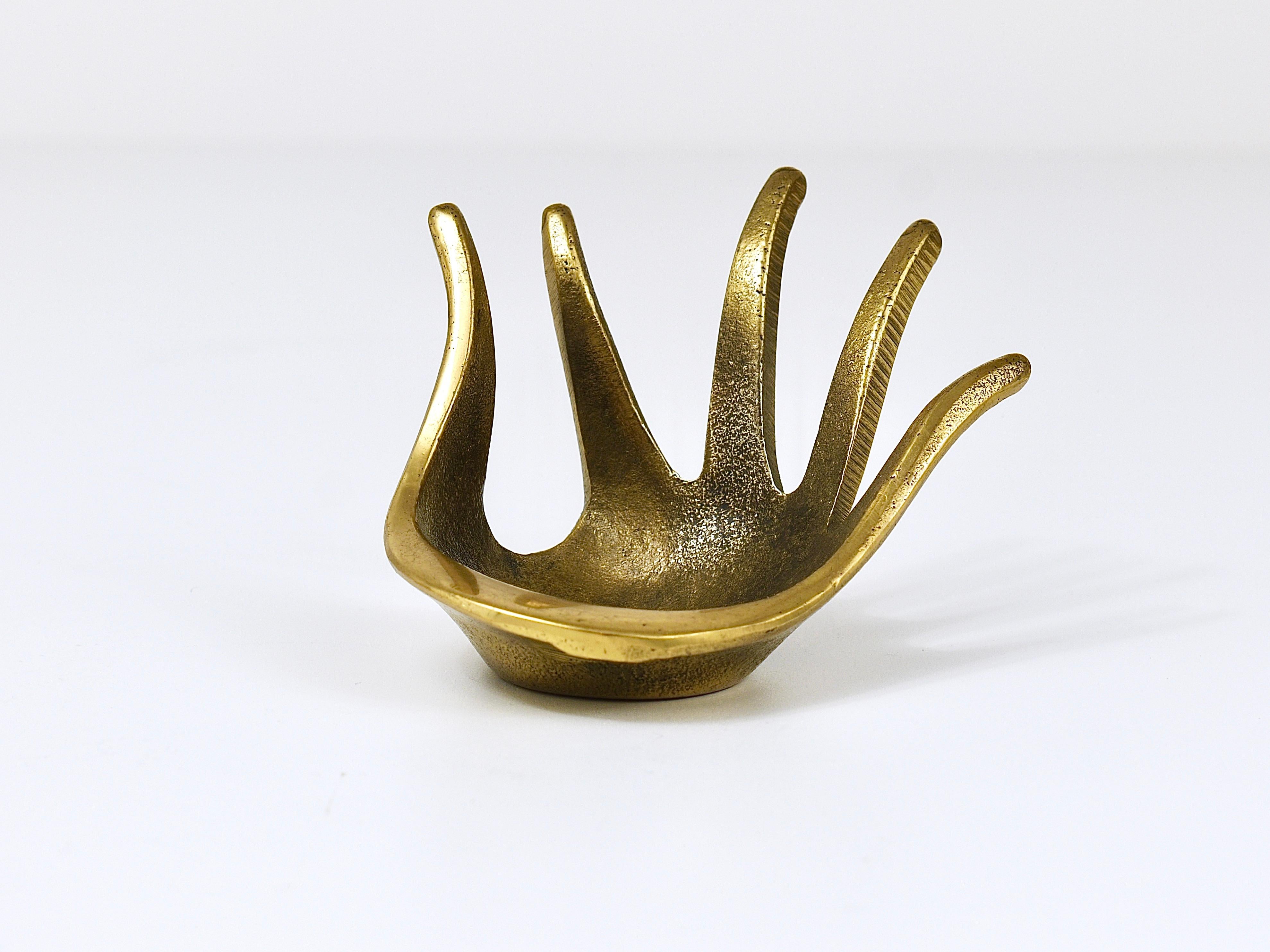 A beautiful sculptural modernist brass bowl in the shape of a hand. Originally designed as an ashtray this elegant brass object is also suitable as a jewelry bowl, a ring holder or as a a „vide-poche“. A humorous design by Walter Bosse, executed by
