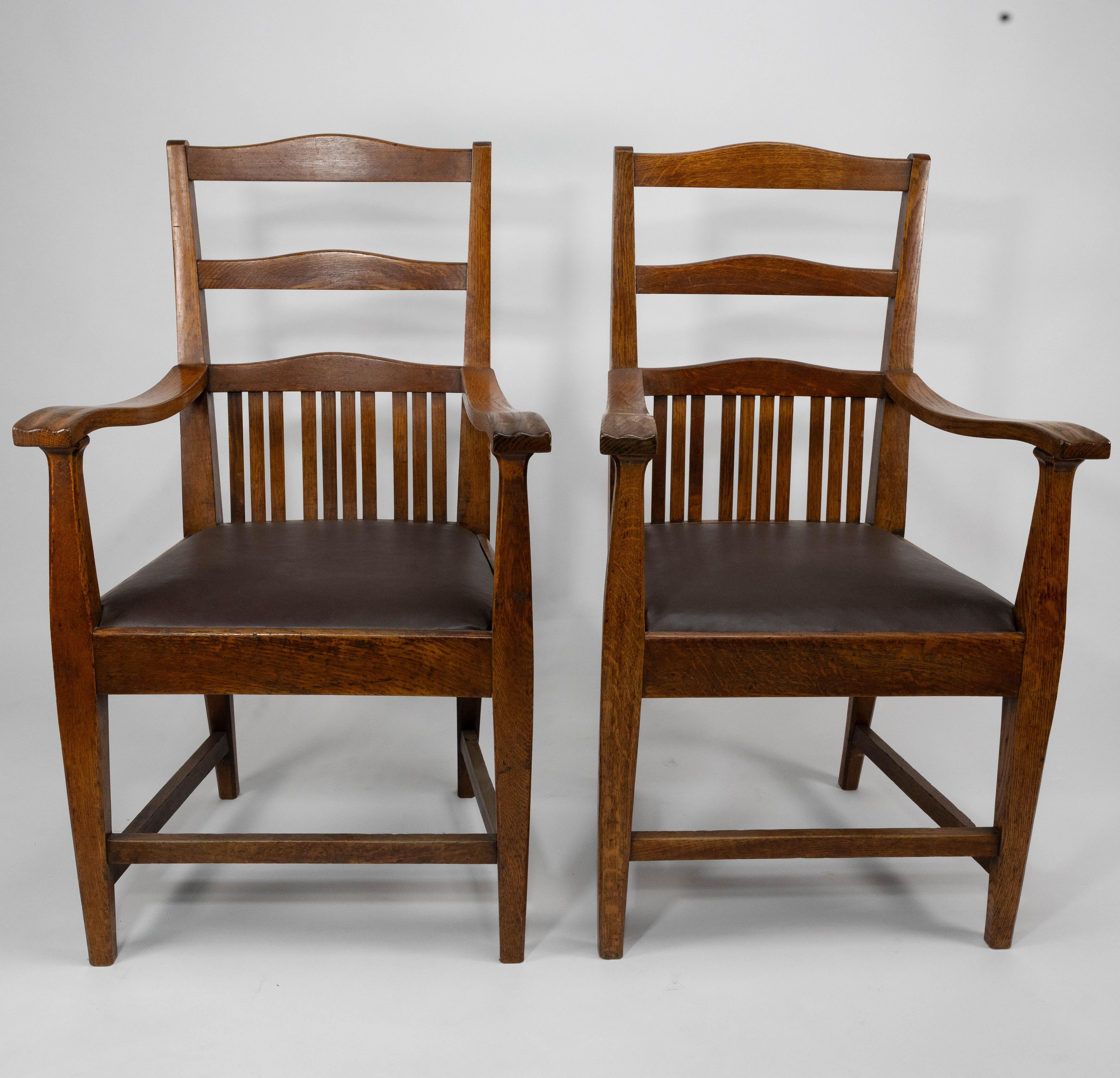 Walter Cave a attribué. Une paire confortable de fauteuils en chêne de style Arts & Crafts avec des dossiers incurvés et des détails subtilement sculptés sur les accoudoirs.