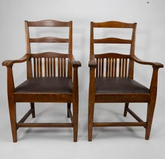 Walter Cave Attri. A pair of Arts & Crafts oak armchairs with curvaceous backs
