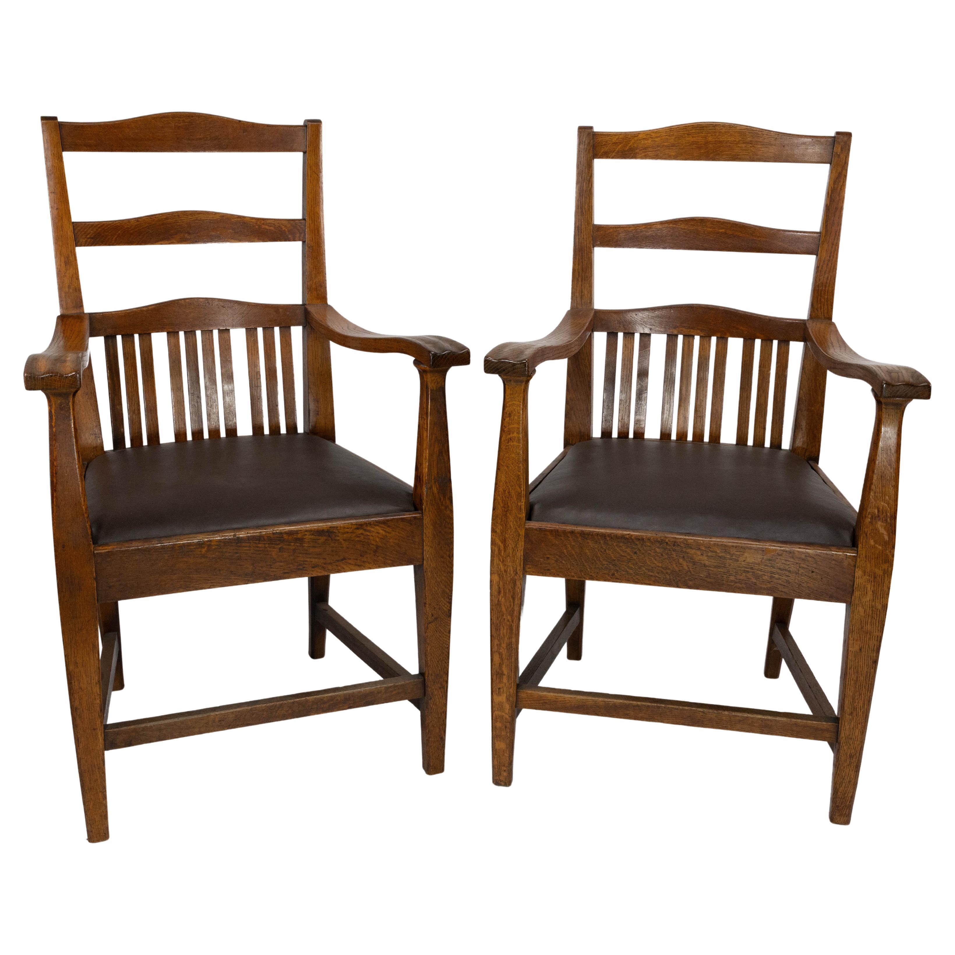 Walter Cave Attri. A pair of Arts & Crafts oak armchairs with curvaceous backs
