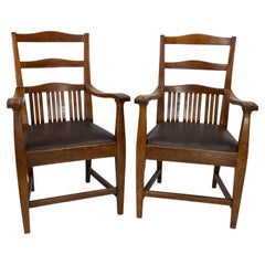 Walter Cave Attri. A pair of Arts & Crafts oak armchairs with curvaceous backs