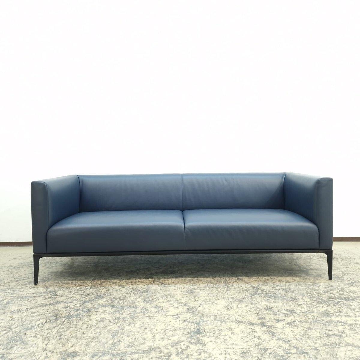 Das Jaan Living Sofa von Walter Knoll, entworfen vom Designstudio EOOS, ist ein Paradebeispiel für moderne Eleganz und Komfort. Die großzügigen Polsterflächen des Sofas und der Récamiere scheinen über dem filigranen Gestell zu schweben, was eine