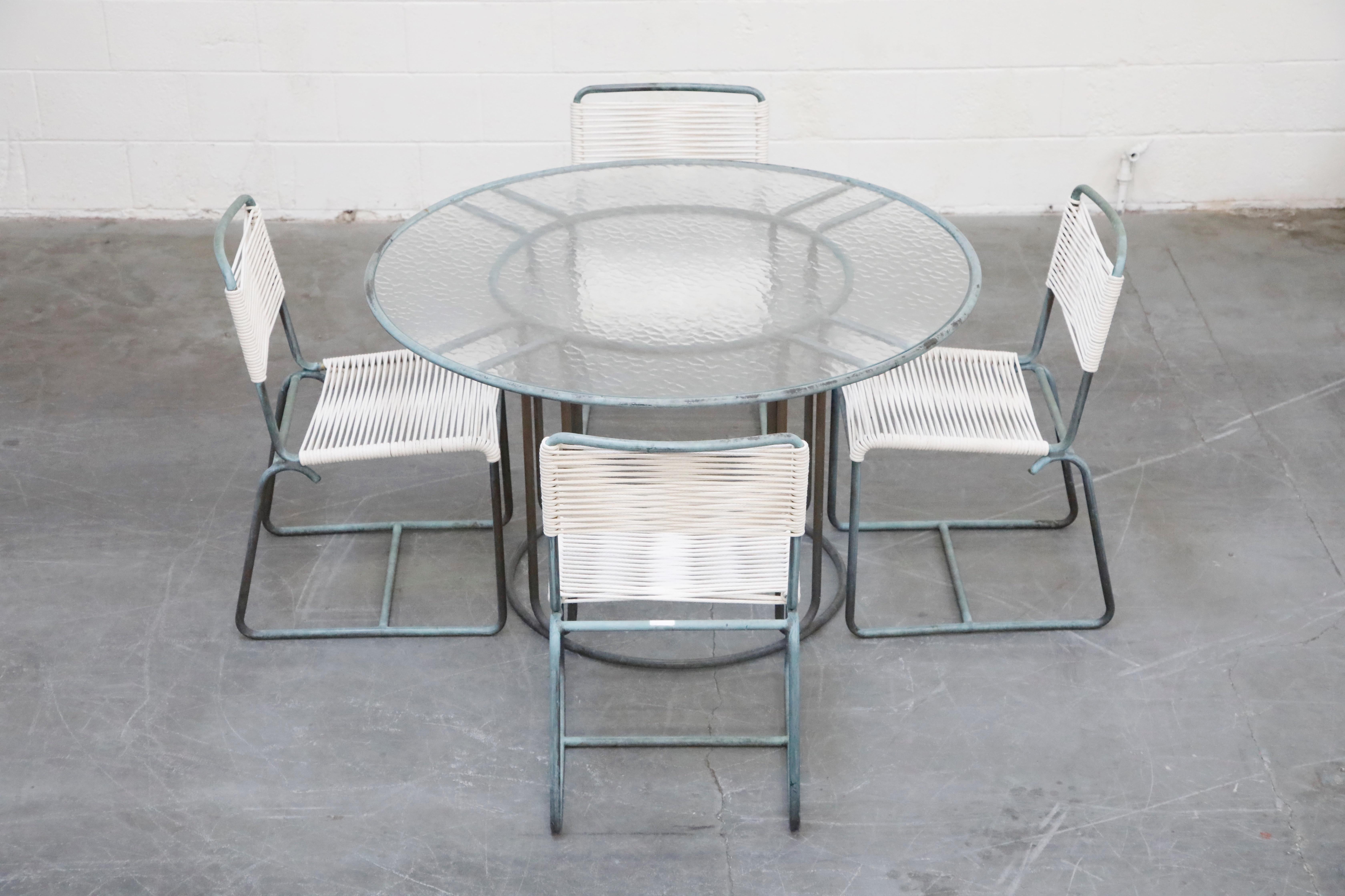 This highly-sought-after and collectible dining set comprised of four bronze dining chairs and a 48.5