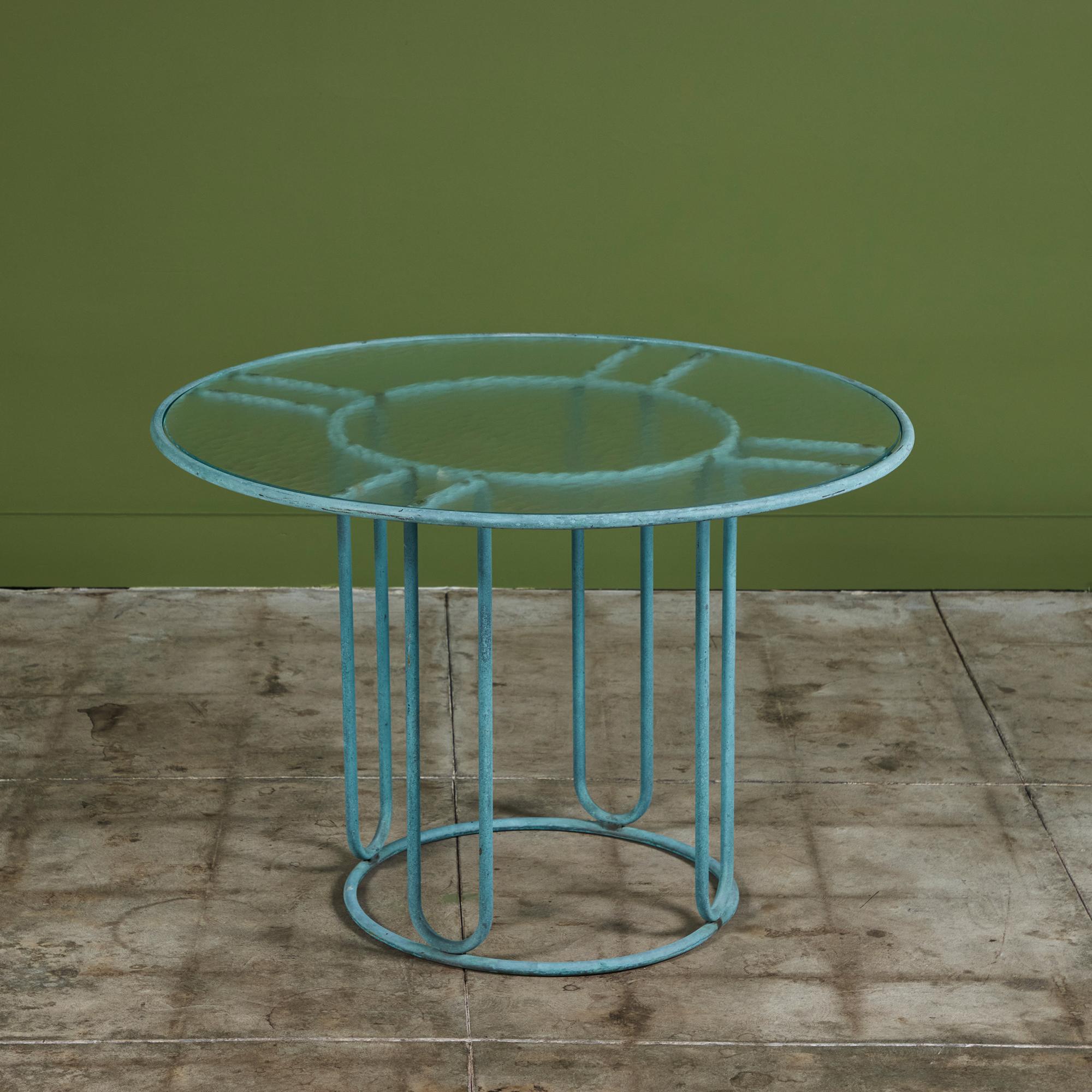Table de patio en bronze patiné conçue par Walter Design/One et produite par Brown Jordan. Le cadre rond est décrit par deux anneaux concentriques de bronze avec des supports radiaux et une base circulaire en bronze. Le plateau rond est une pièce