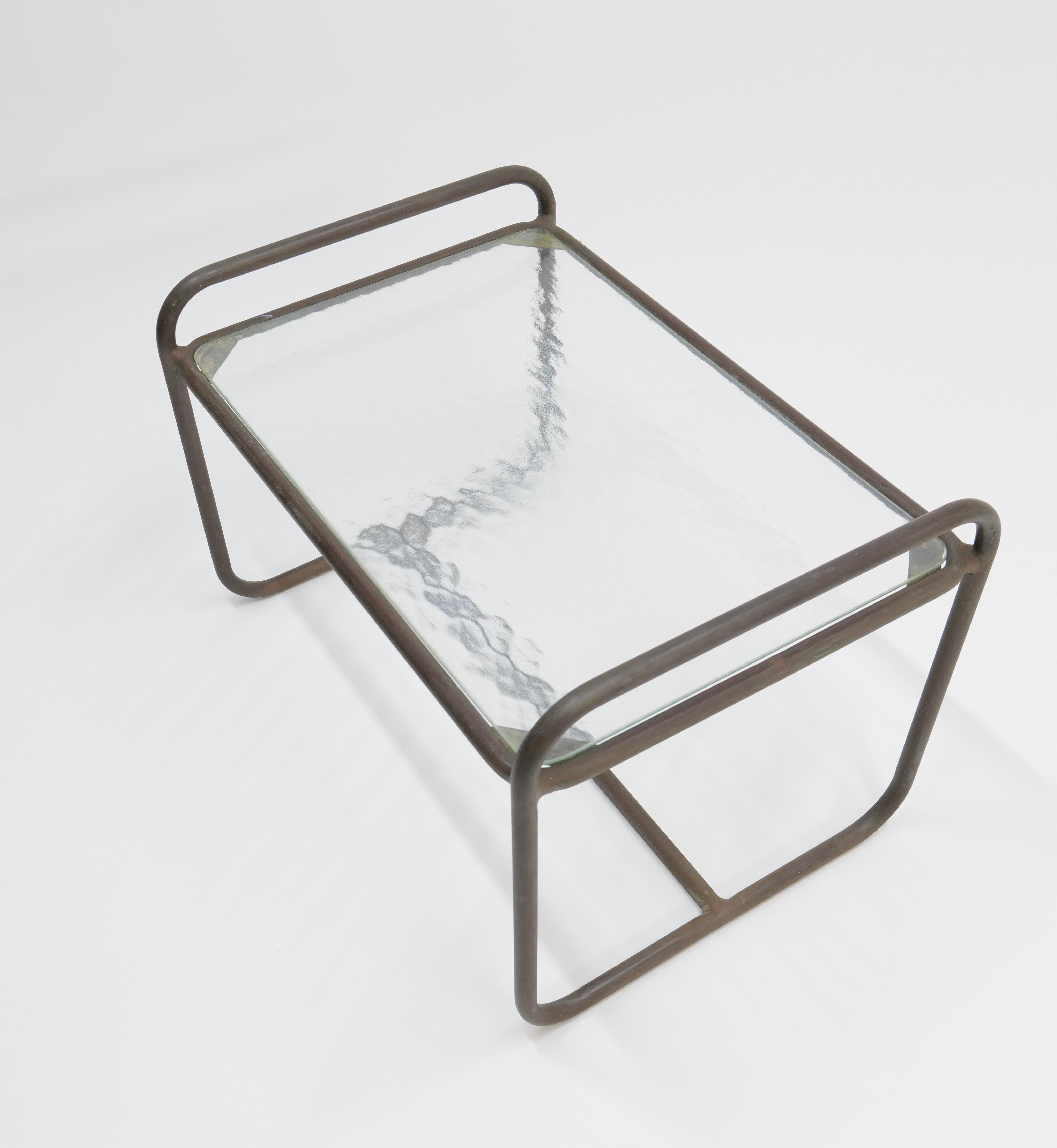Cette table d'appoint de terrasse en bronze, créée par Walter Lamb pour Brown Jordan, est un exemple classique du style de Lamb, qui allie des lignes modernistes à des matériaux durables adaptés à la vie en plein air. La table est dotée d'une