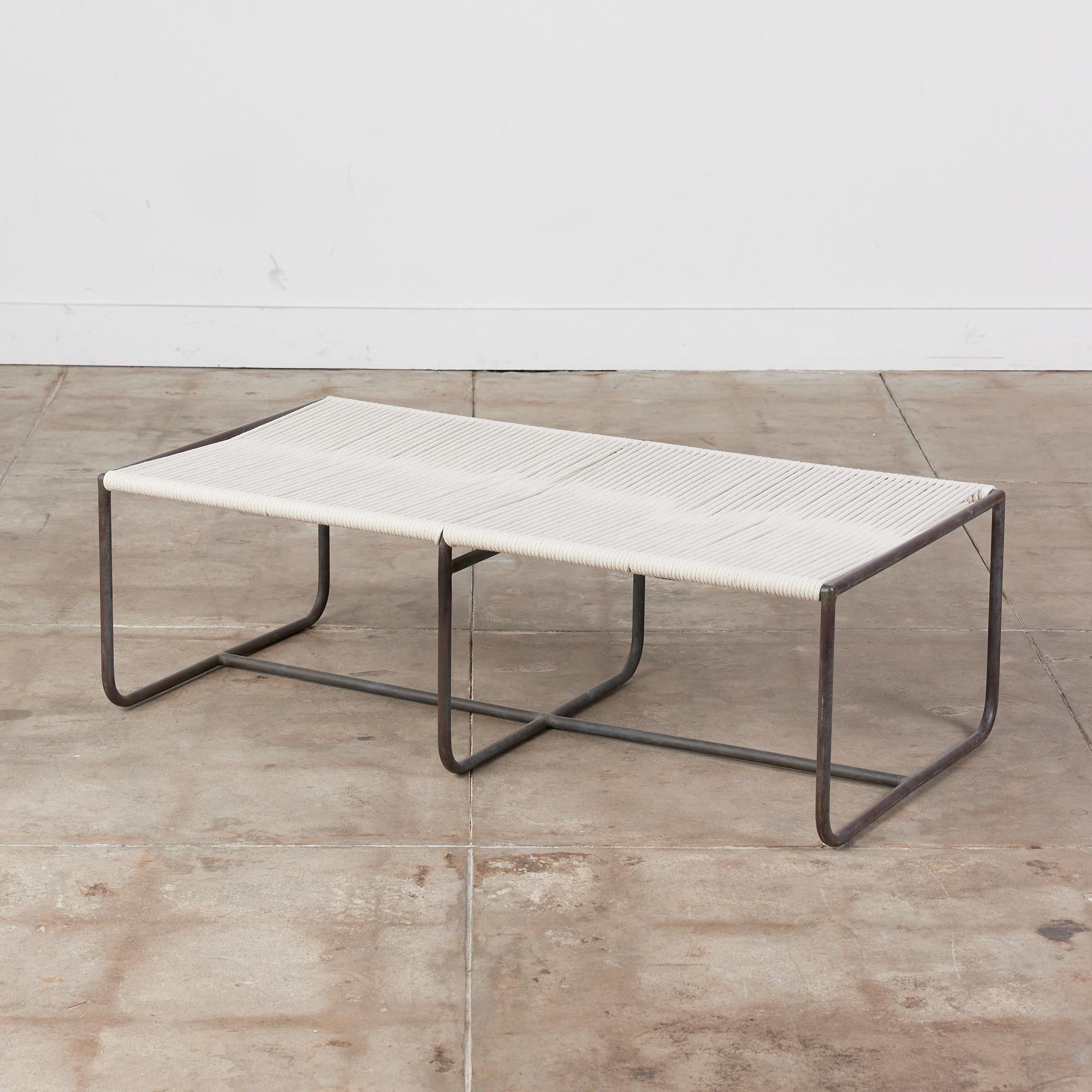 Bronze two seater bench by Walter Lamb for Brown Jordan. The bench has simple construction in tubular bronze with a patinated finish. The bench has three rounded square supports and a stretcher that runs the length of the piece. 

All Walter Lamb