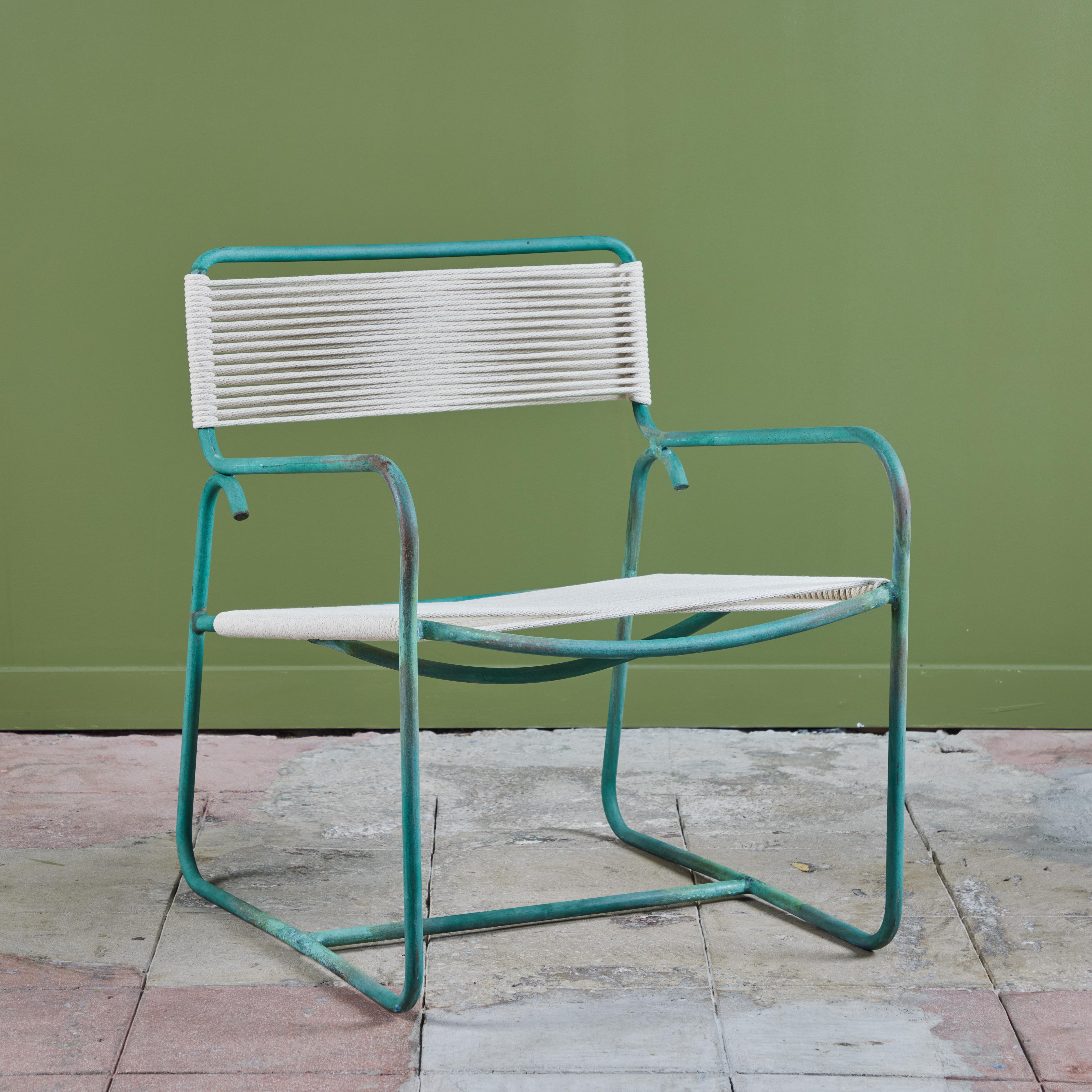 A wide patio lounge chair by Walter Lamb for Brown Jordan. The chair has a simple construction in tubular bronze with a patinated finish, with rounded squares serving as runners on each side. The backrest, and seat are both woven in cotton sail