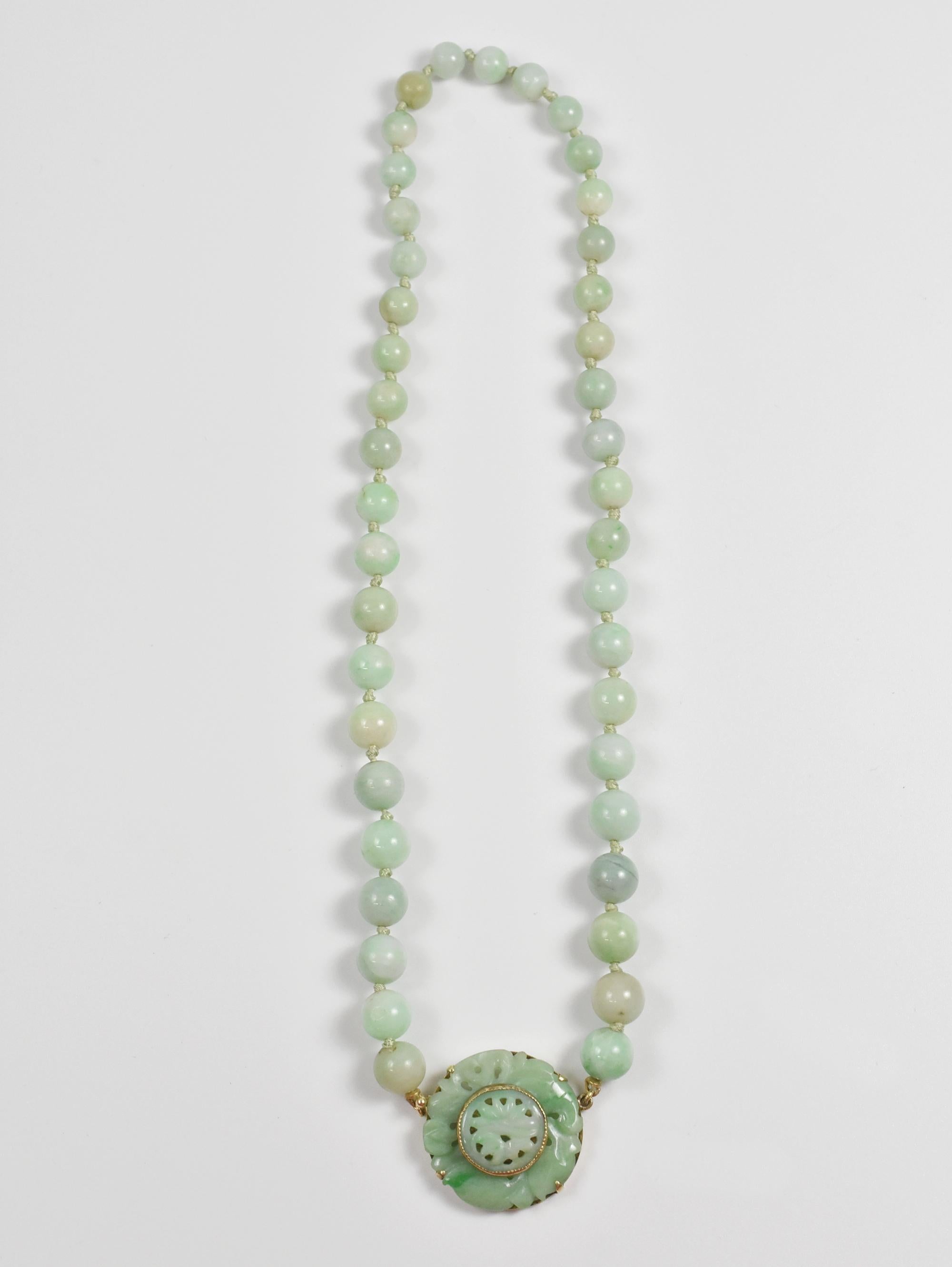 Walter Lampl carved jade necklace. Single strand jade beaded necklace with a carved jade medallion, closure in 14-karat gold, setting stamped 