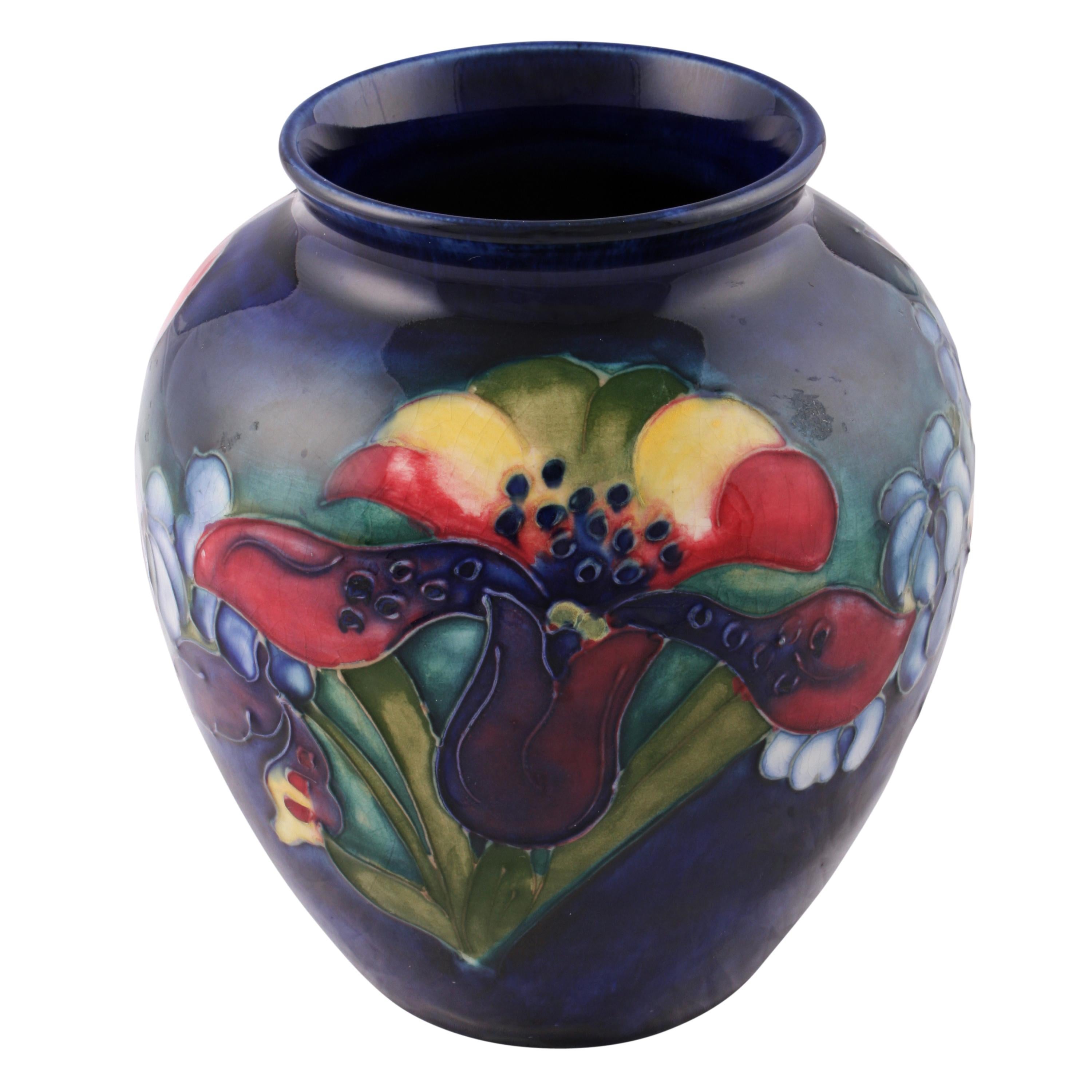 A 20th century moorcroft pottery 'Orchid' pattern vase.

The vase has underneath the impressed mark 'Moorcroft Made In England' and the 'W M' signature in blue for Walter Moorcroft.

The vase is in good condition, circa 1950)

Measures: Height