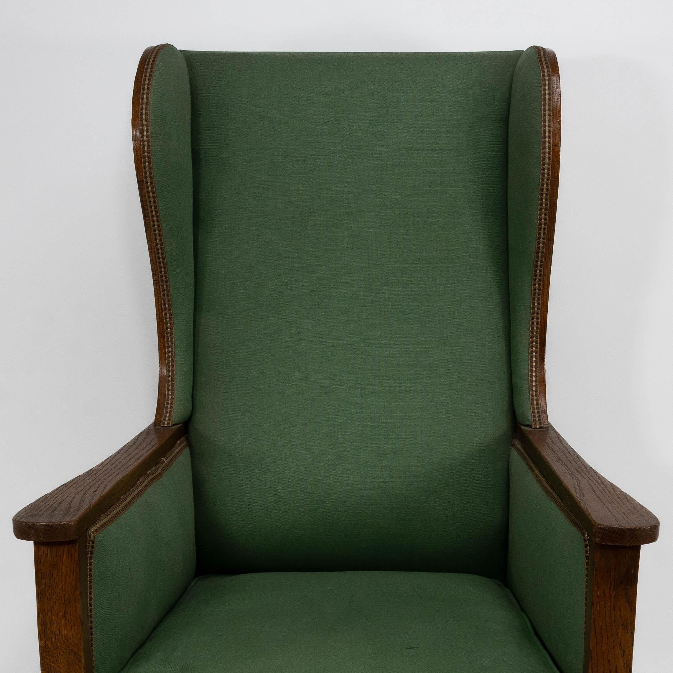 Walter Skull High Wycombe. An Arts and Crafts oak wing back upholstered armchair In Good Condition For Sale In London, GB