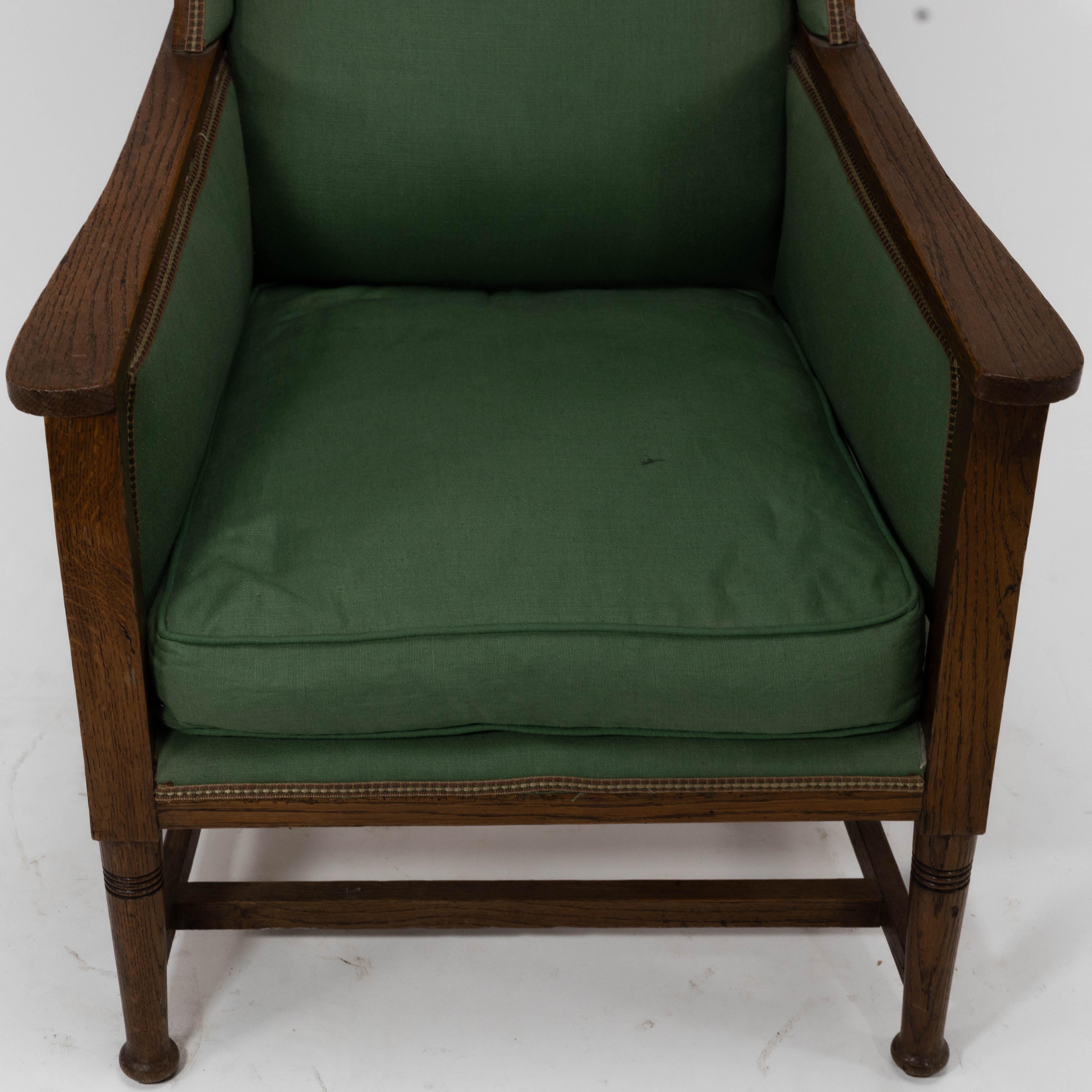 Early 20th Century Walter Skull High Wycombe. An Arts and Crafts oak wing back upholstered armchair For Sale