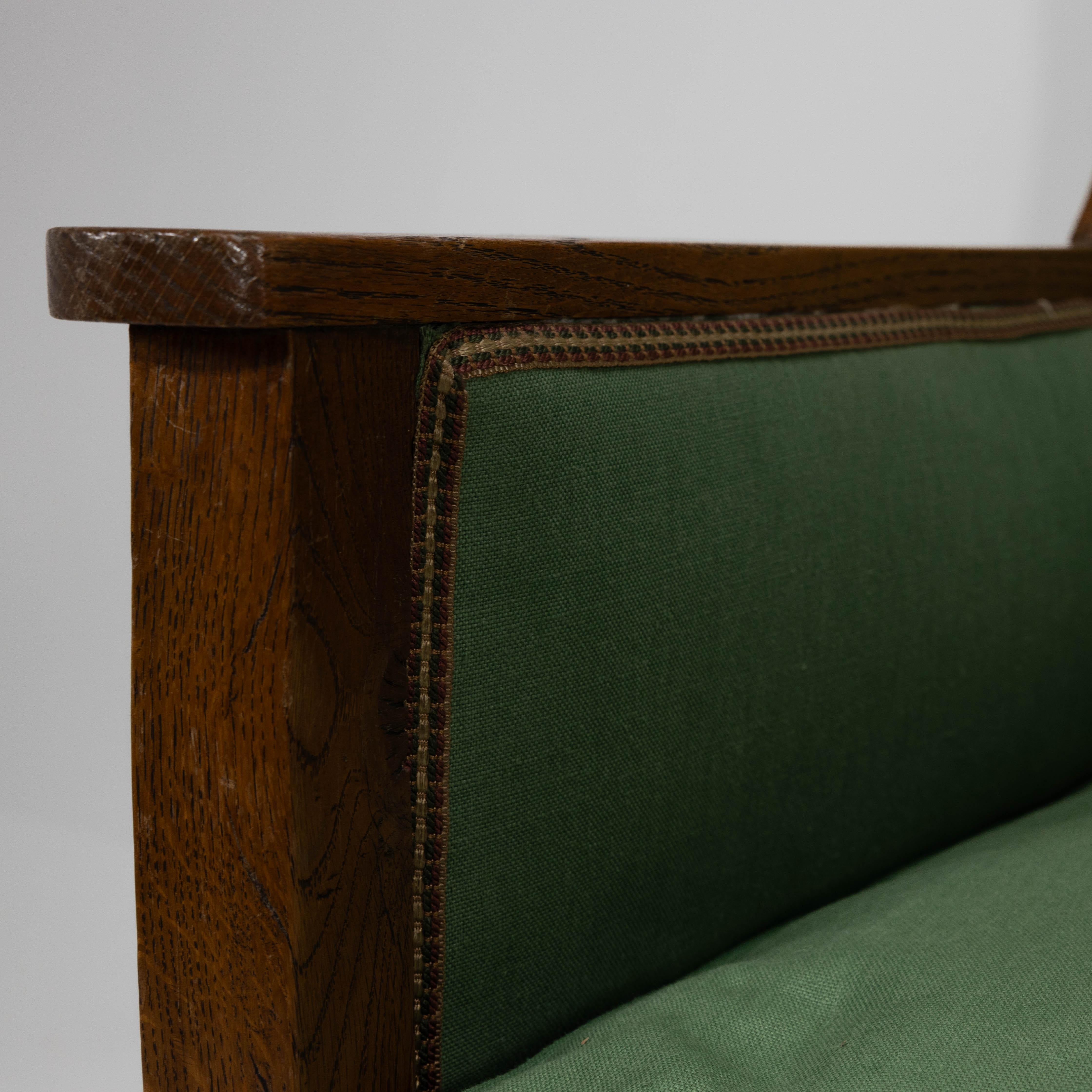 Oak Walter Skull High Wycombe. An Arts and Crafts oak wing back upholstered armchair For Sale