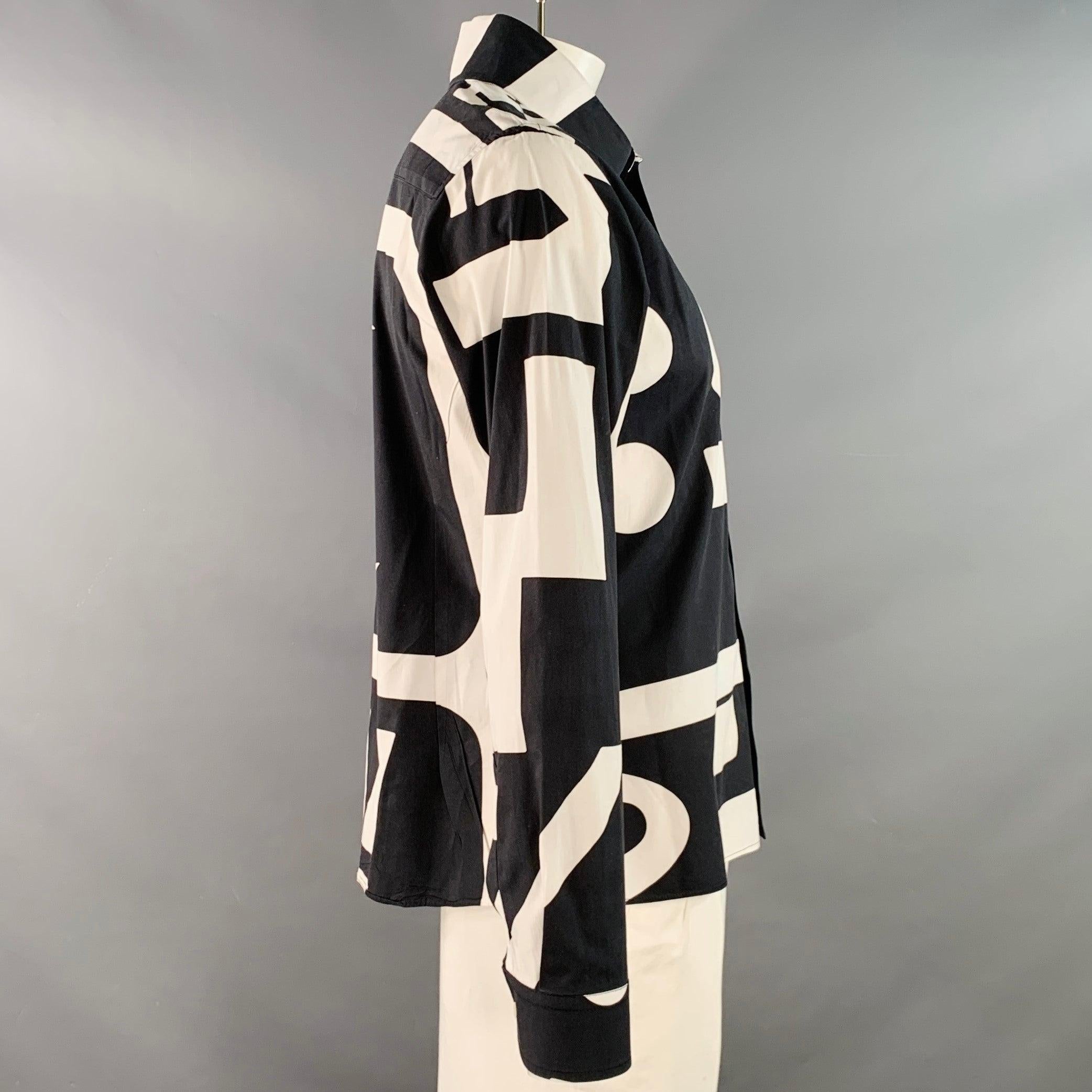 Camicia a maniche lunghe Walter Van Beirendonck
in tessuto di cotone bianco e nero con stampa grafica all over, colletto aperto e chiusura con bottoni. Made in Romania.Eccellente condizione di usato. 

Contrassegnato:   L 

Misure: 
 
Spalla: 18