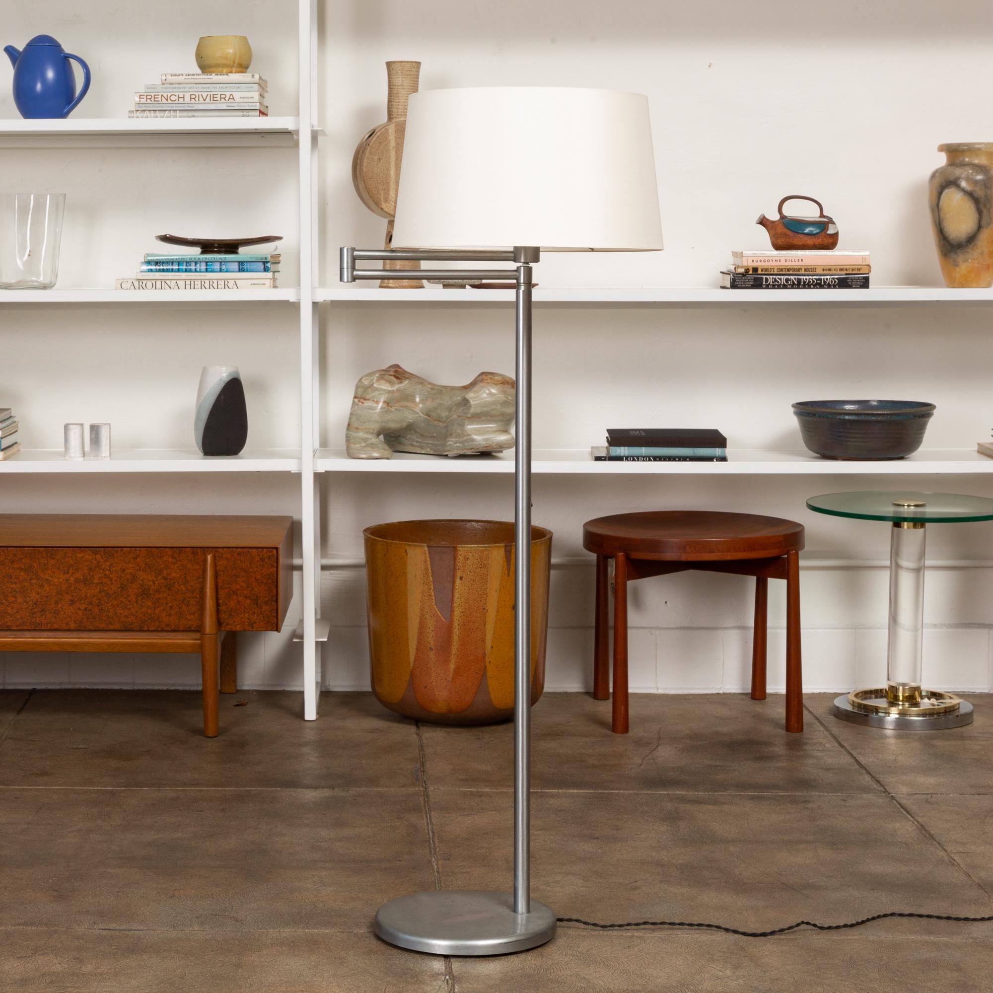 A nickel floor lamp by Walter Von Nessen for Nessen Studios. The lamp features a nickel body with an height adjustable stem and adjustable swing arm. The lamp has a new custom silk lamp shade and has been newly rewired with braided cloth