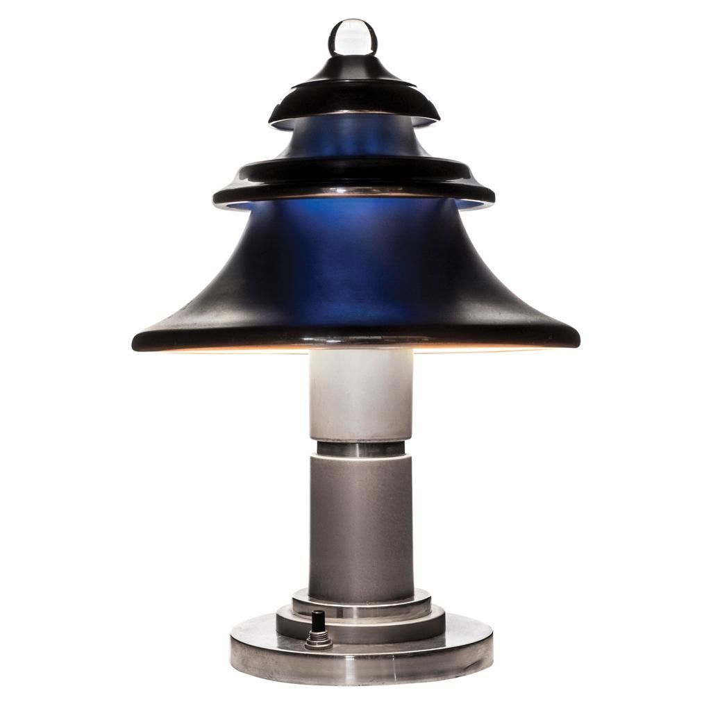An interesting Machine Age aluminium table lamp by German-born American designer Walter Von Nessen. The 3-level mushroom shaped design with frosted finish and bright polished borders shows a sphere glass topper. Interior has a blue screen that makes