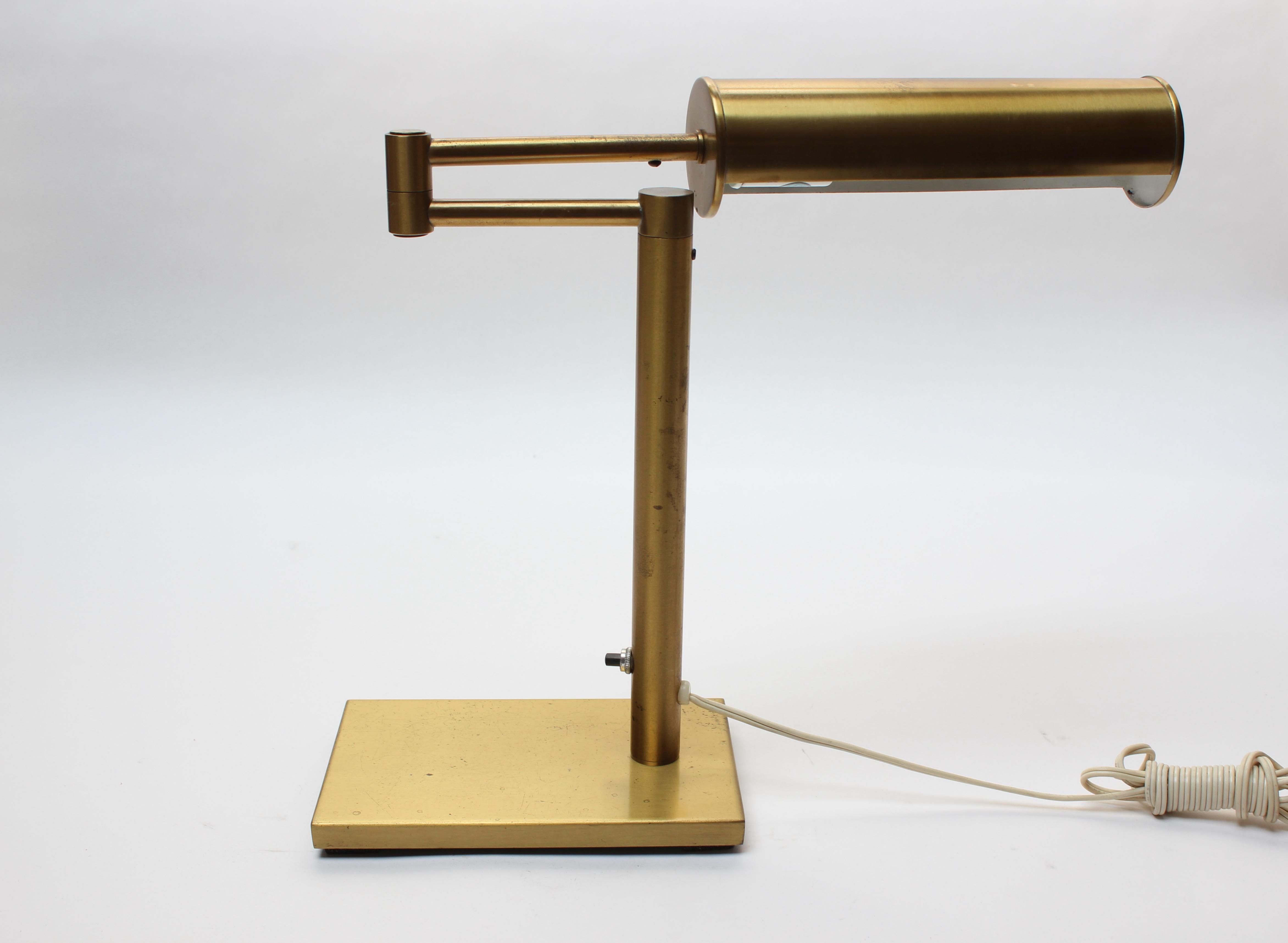 Attractive and highly functional desk / table lamp by Walter Von Nessen for his eponymous Nessen Studio (ca. 1970s, New York City). Features a swing arm and pivoting, perforated, cylindrical shade. 
Natural, warm patina present along with light,