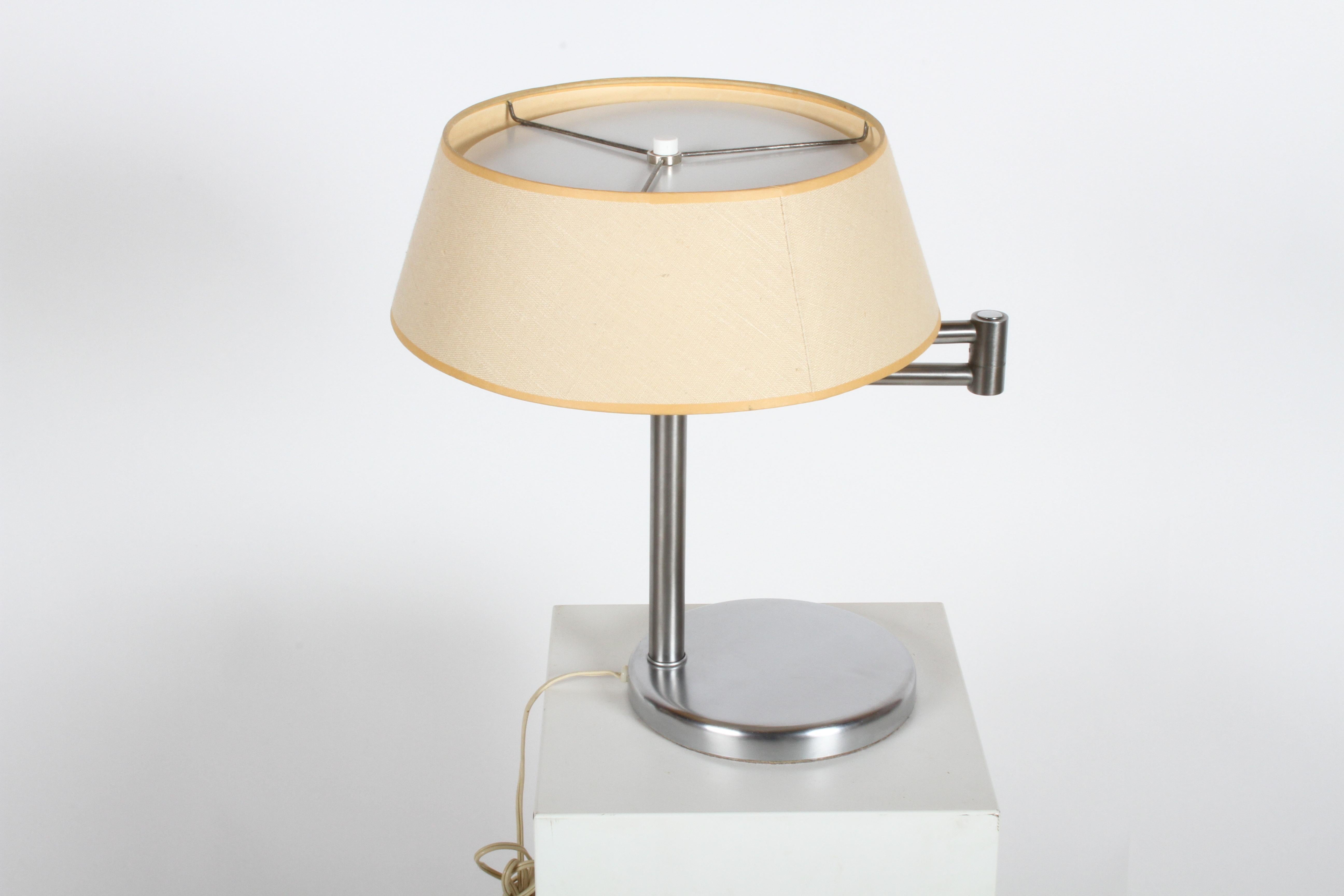 Listed is Walter Von Nessen's most famous lamp, which he designed in 1930s. This swing-arm Classic in brushed nickel is in very nice condition, and production date is sometime in the late 1950s. Has original linen shade, white reflector disc, and S