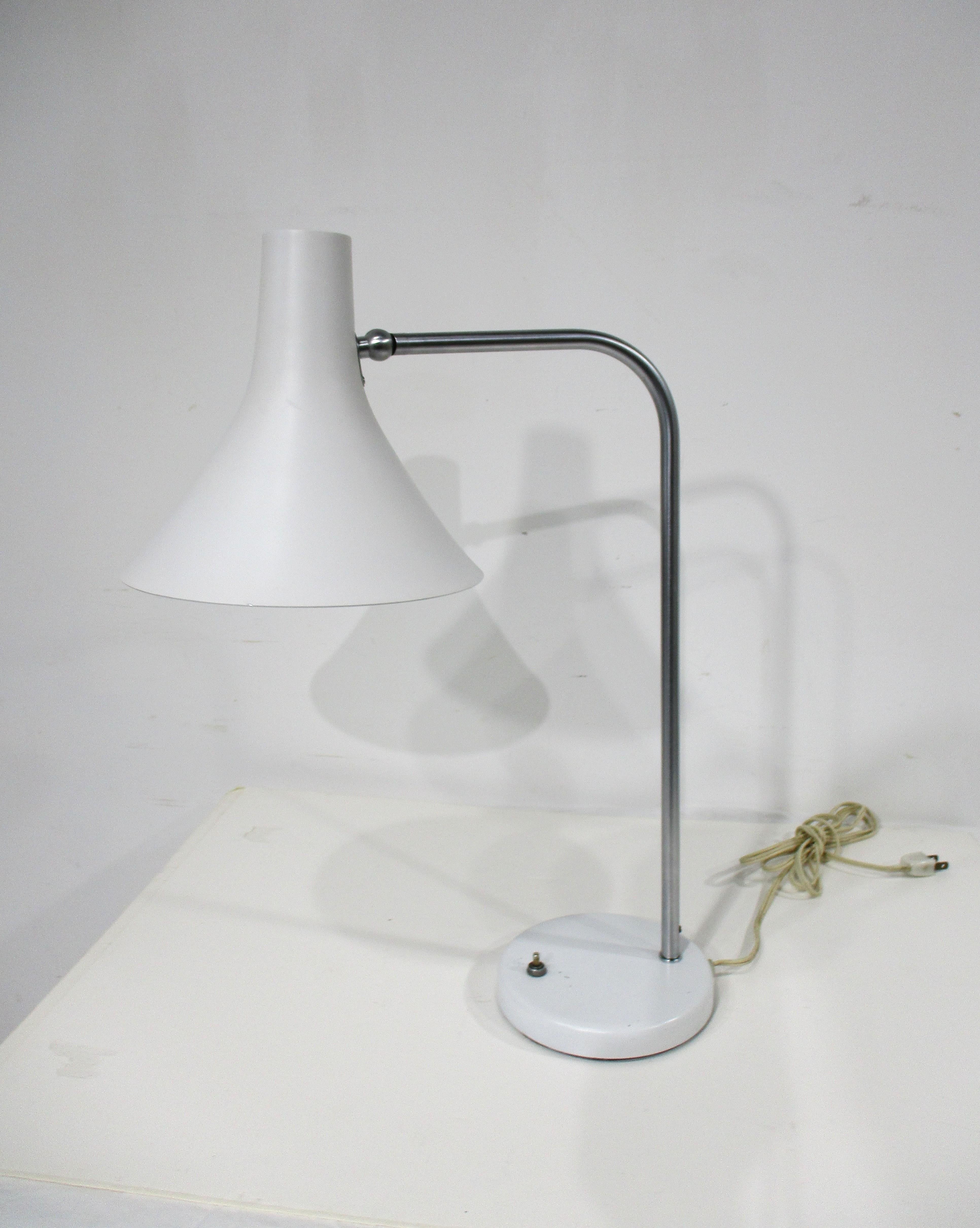 Lampe de bureau ou de table en métal blanc de forme conique évasée, très bien travaillée, avec personnel en acier inoxydable brossé. La lourde base ronde assortie est dotée d'un interrupteur à bouton-poussoir et d'un abat-jour pivotant et inclinable