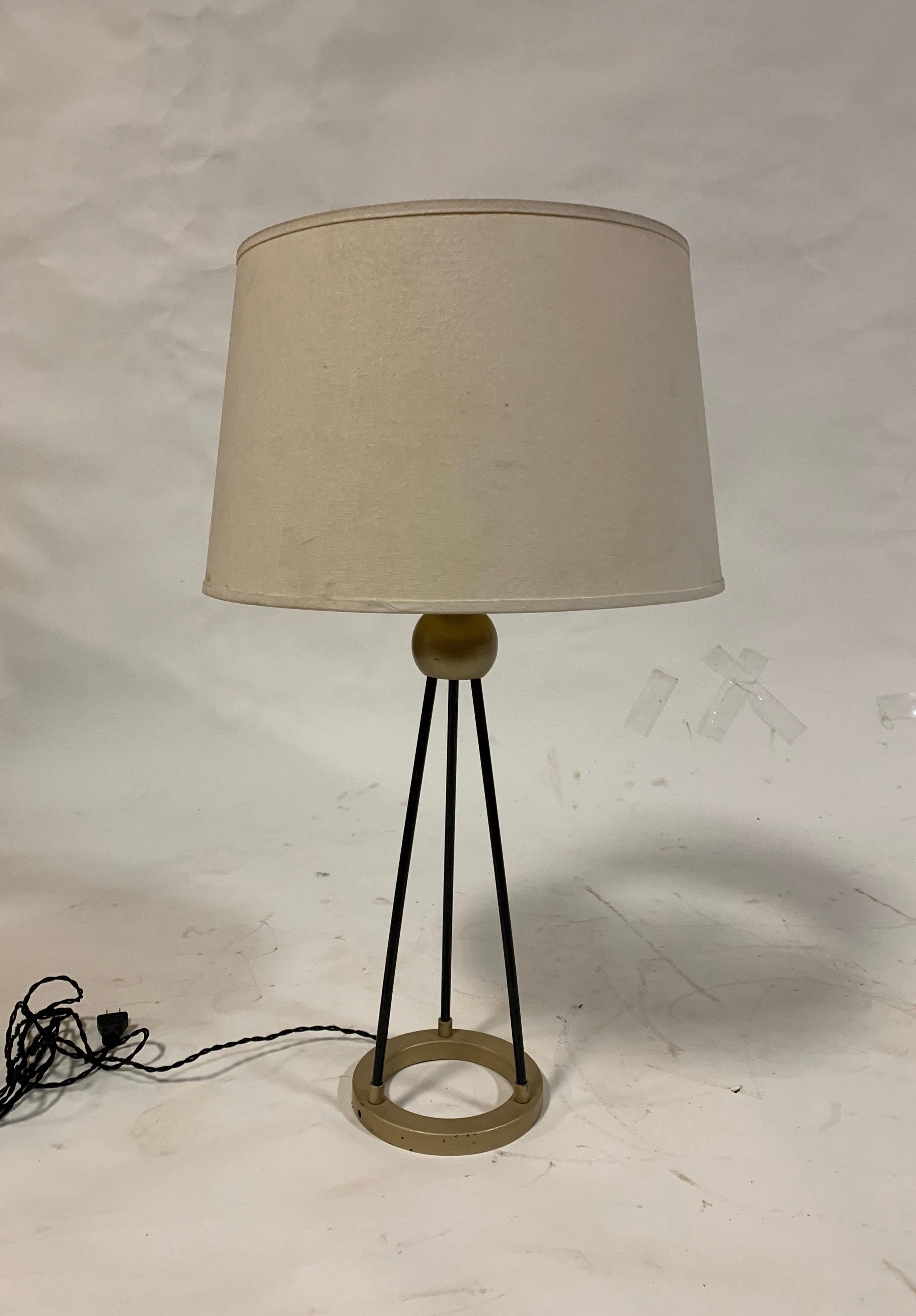 A brass and black metal table lamp; possibly by Walter Von Nessen. USA, circa 1940. Rewired with new sockets and French black silk twisted cord.

Takes one standard US bulb, 75 watts max.

Includes off white linen drum