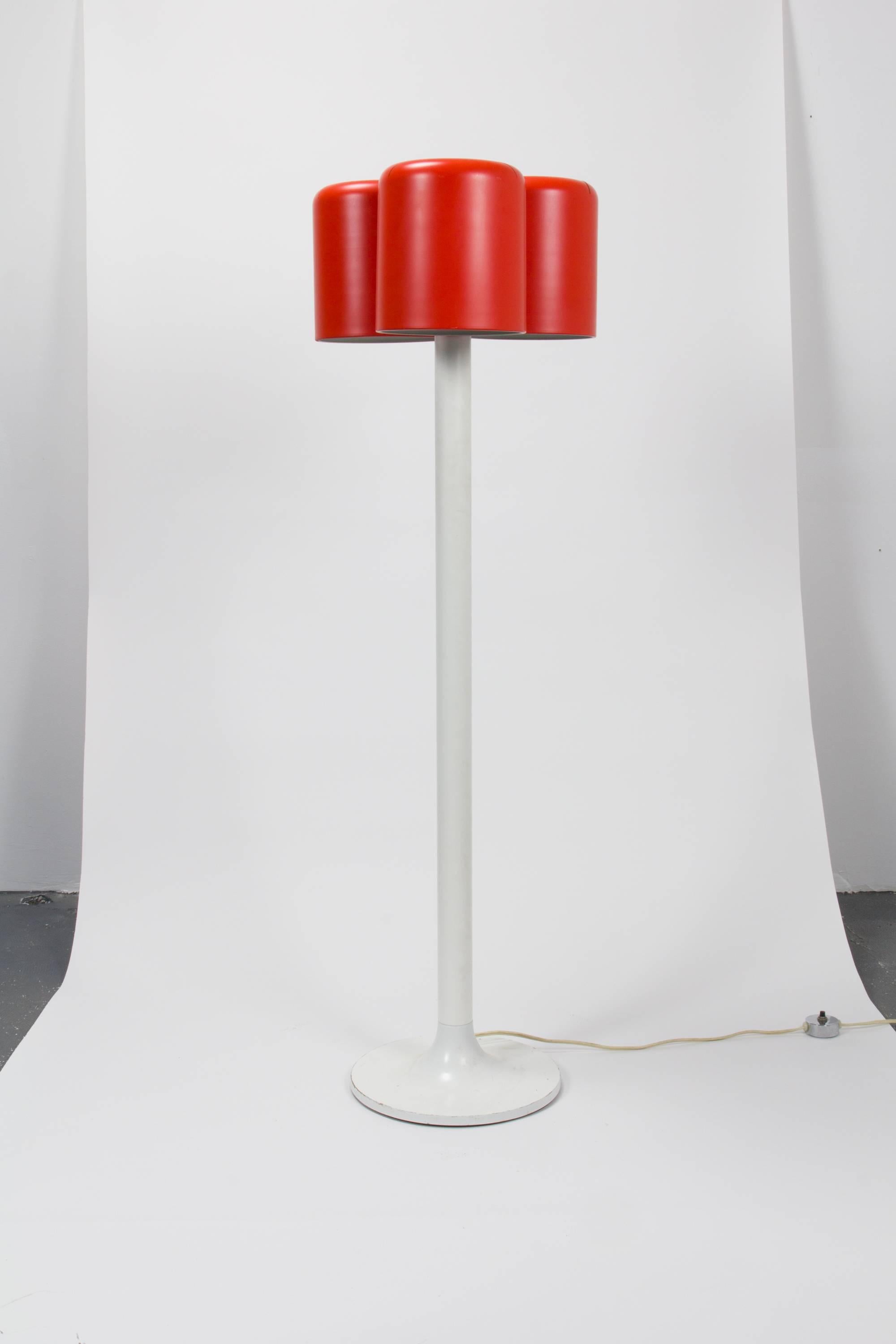 Uncommon three-shade floor lamp by Walter Von Nessen having three satin red cylindrical metal shades and white enamel body.