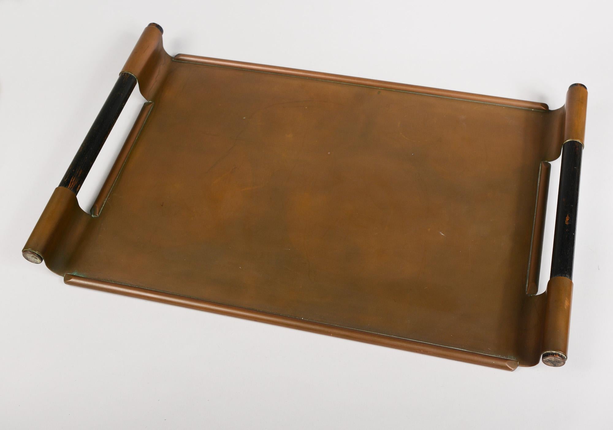 Chase Tiffin tray in copper designed by Walter Von Nessen. This tray is in original condition. It shows normal wear. There is some paint loss on the wood handles. One side of one handle appears to be bent in slightly towards the tray. This tray is