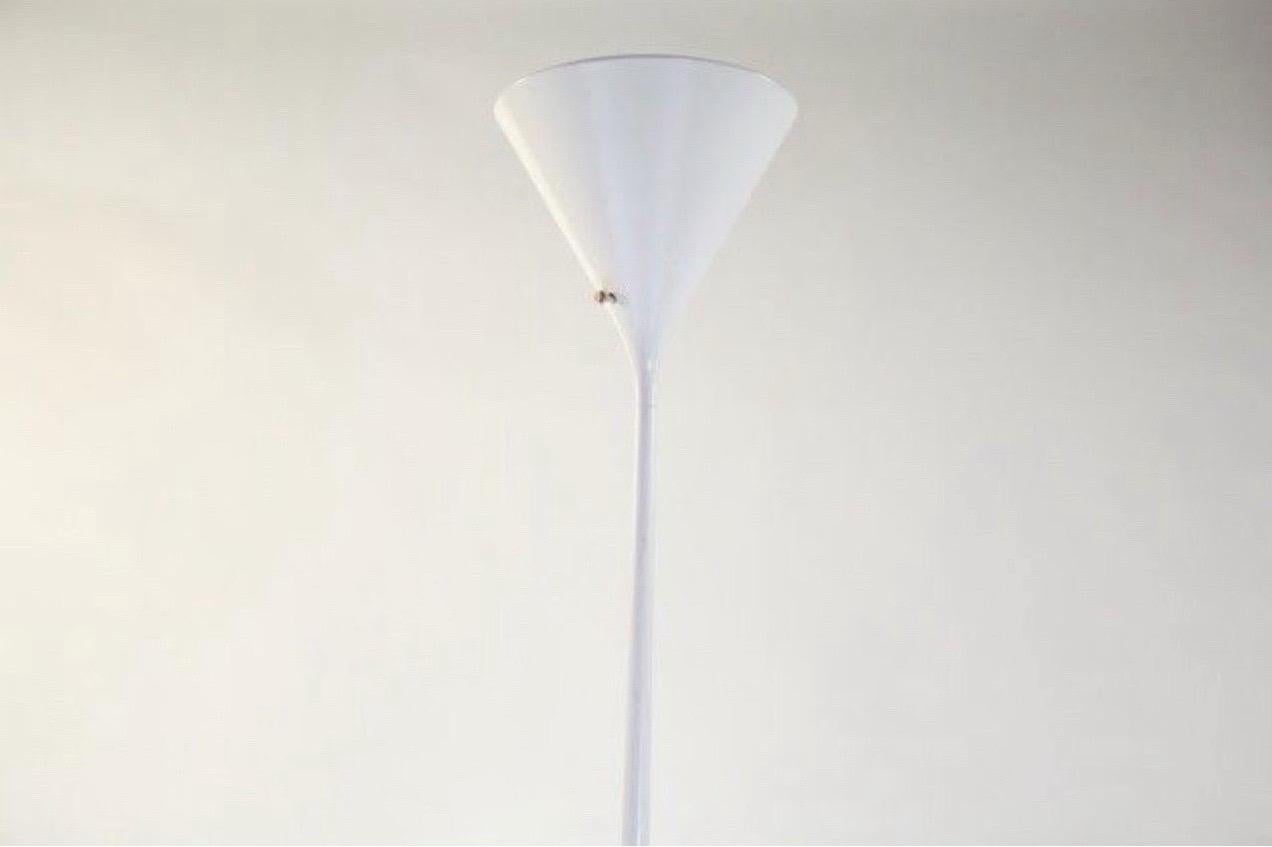 Walter von Nessen white torchiere-style floor lamp.  

Made by Nessen Studio, Inc.

USA, circa 1970.

Enameled aluminum, plastic.

Signed with cast manufacturer's mark to underside of base: [Nessen Studio].

Lamp takes one large base U.S. bulb, 100