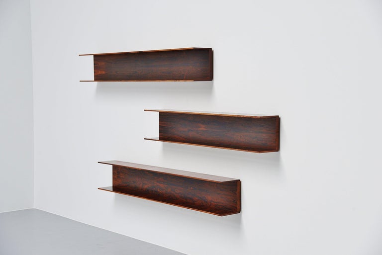Super nice Minimalist set of 3 large wall shelves designed by Walter Wirtz and manufactured by Wilhelm Renz, Germany, 1965. These shelves are made of rosewood veneer and are easy to wall hang using only 2 screws per shelve. The shelves have a very