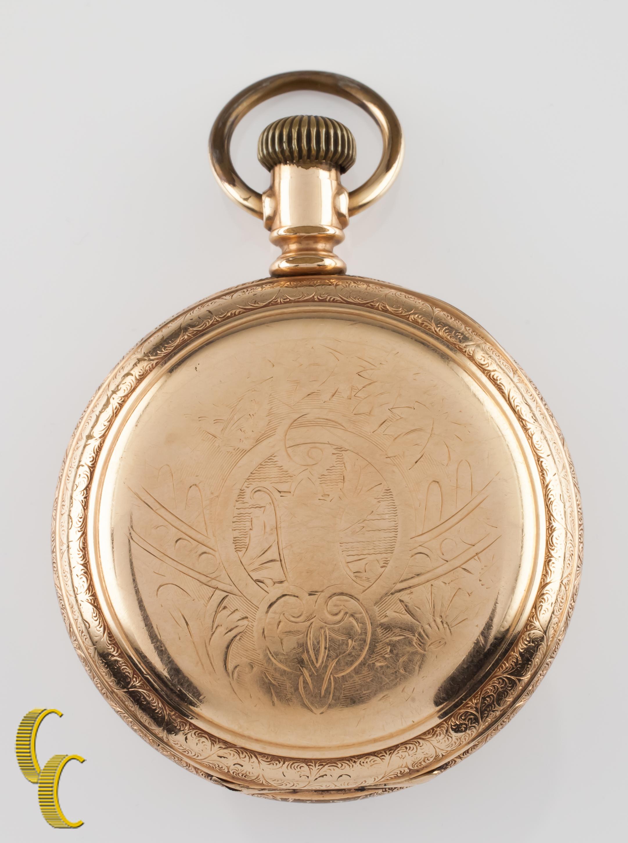 Precioso reloj de bolsillo Waltham antiguo con esfera blanca.
Agujas azules y esfera dedicada a los segundos.
Caja de oro con un intrincado diseño grabado a mano.
Números y marcadores negros.
Caso número de serie 273984.
Movimiento Waltham de 7