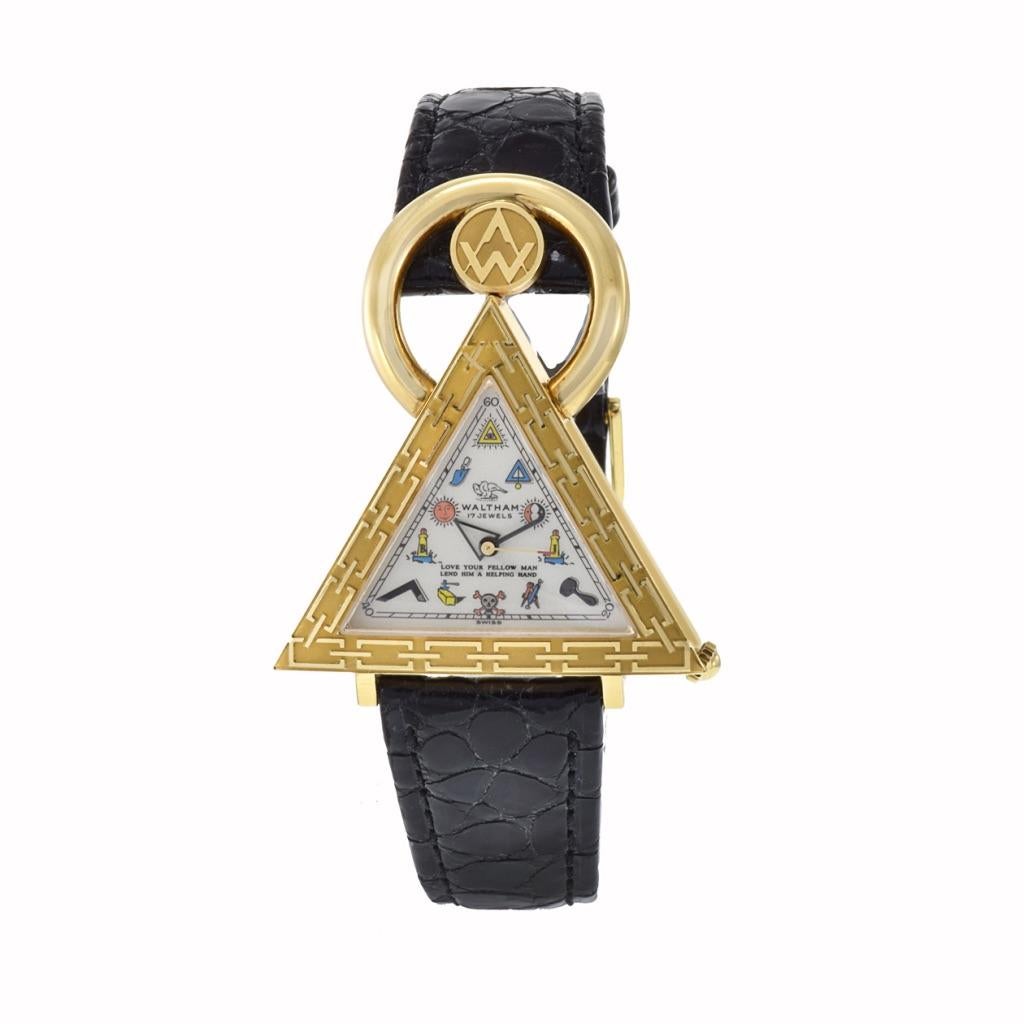 The Waltham 18K Gold Triangular Masonic Wristwatch is a distinctive timepiece with notable features, crafted circa 2000. It houses a nickel-finished lever movement with 17 jewels, ensuring precision and reliability. The silver opaline dial is