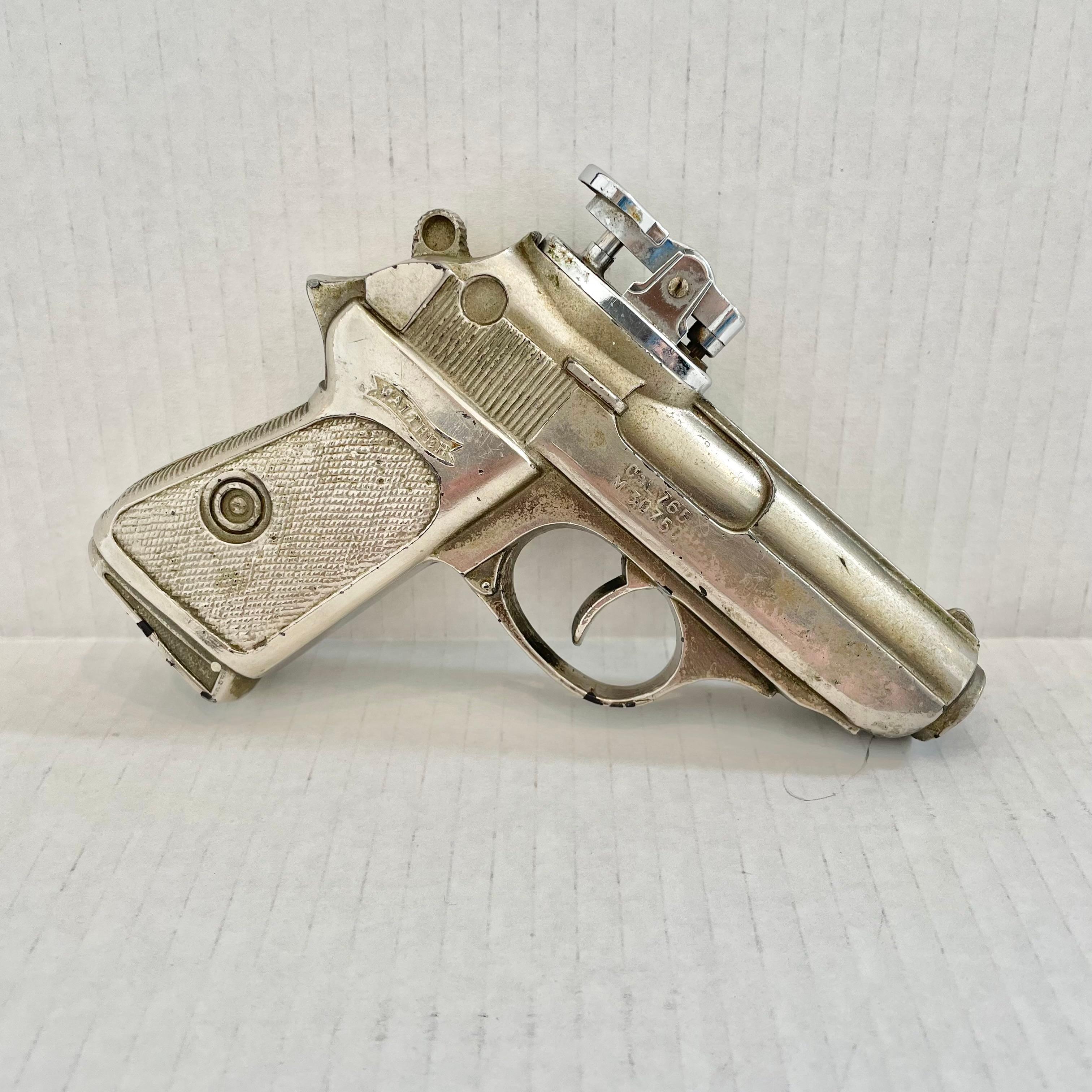 Cool vintage table lighter in the shape of a Walther PPK. Made completely of metal with a hollow body. Beautiful burnished silver color with intricate details. Cool tobacco accessory and conversation piece. Working lighter. Very unusual piece. Made