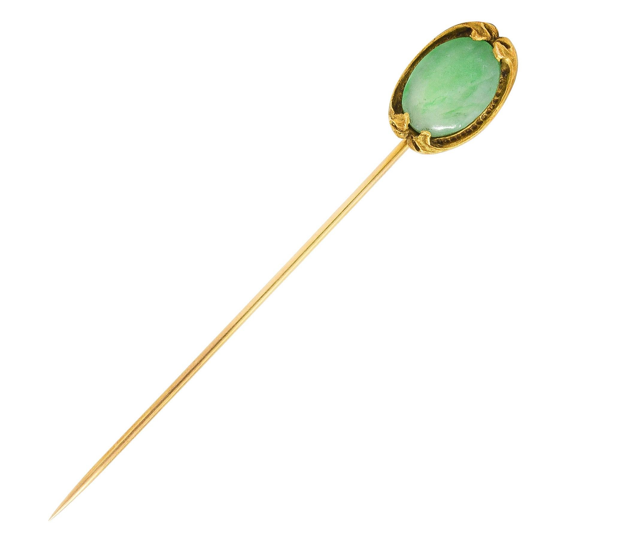 Stickpin designed as stylized ginkgo leaf frame with textured ridges

Centering an oval jade cabochon measuring 12.0 x 9.0 mm

Jade is translucent green with mottling and very good polish

Head tested as 18 karat gold

Fully signed for Walton &