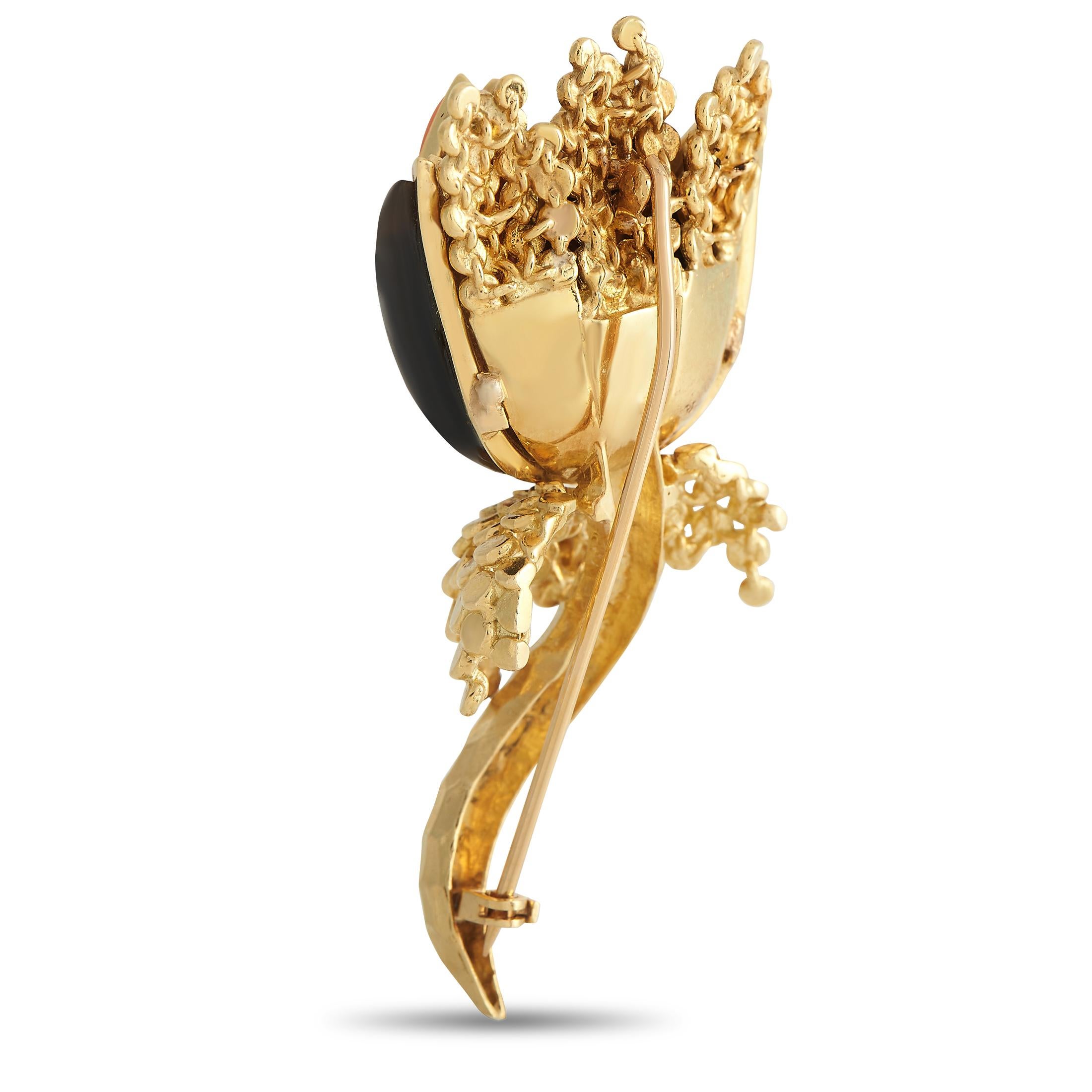 Give your wardrobe the royal treatment by incorporating this statement-making brooch designed in France. It is made from 18K yellow gold and features a flower bud silhouette. The shapely petals come with a coral and citrine inlay. The bud sits atop